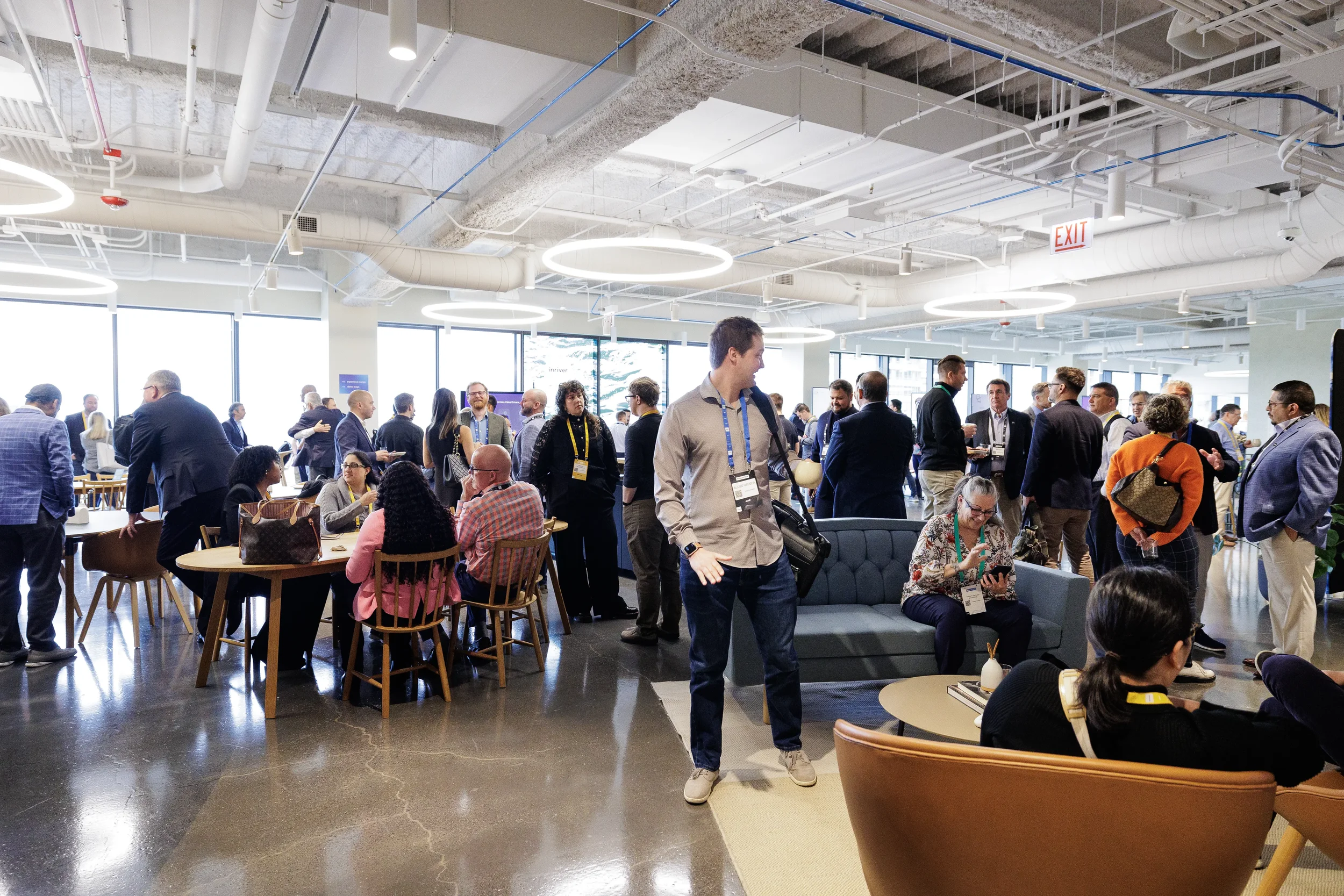 Attendees network in open lounge with ring lighting during Chicago corporate event reception