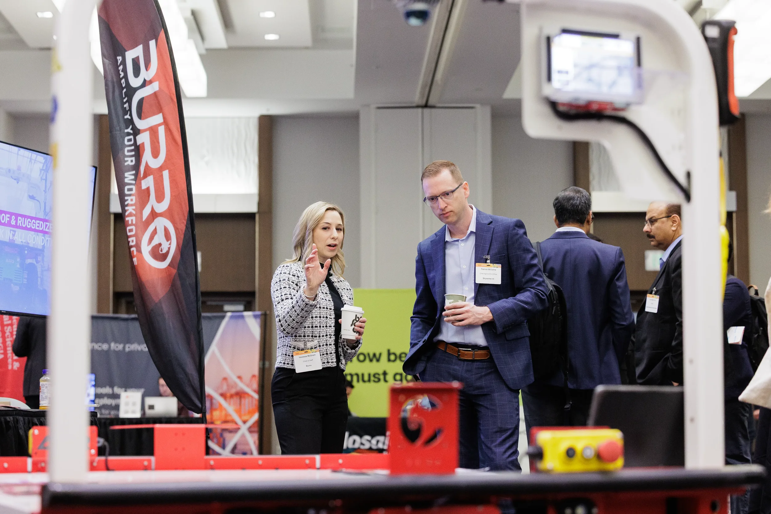 Attendees converse over coffee at exhibitor booth on Chicago expo floor