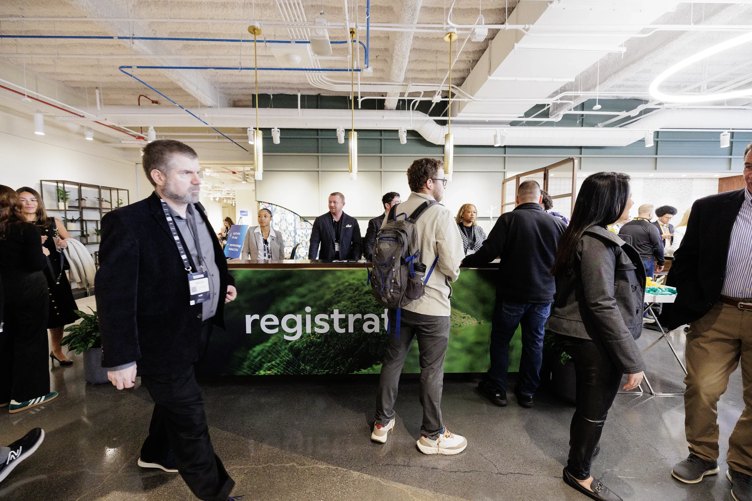Attendees walk past registration desk as staff check in guests at Chicago corporate conference