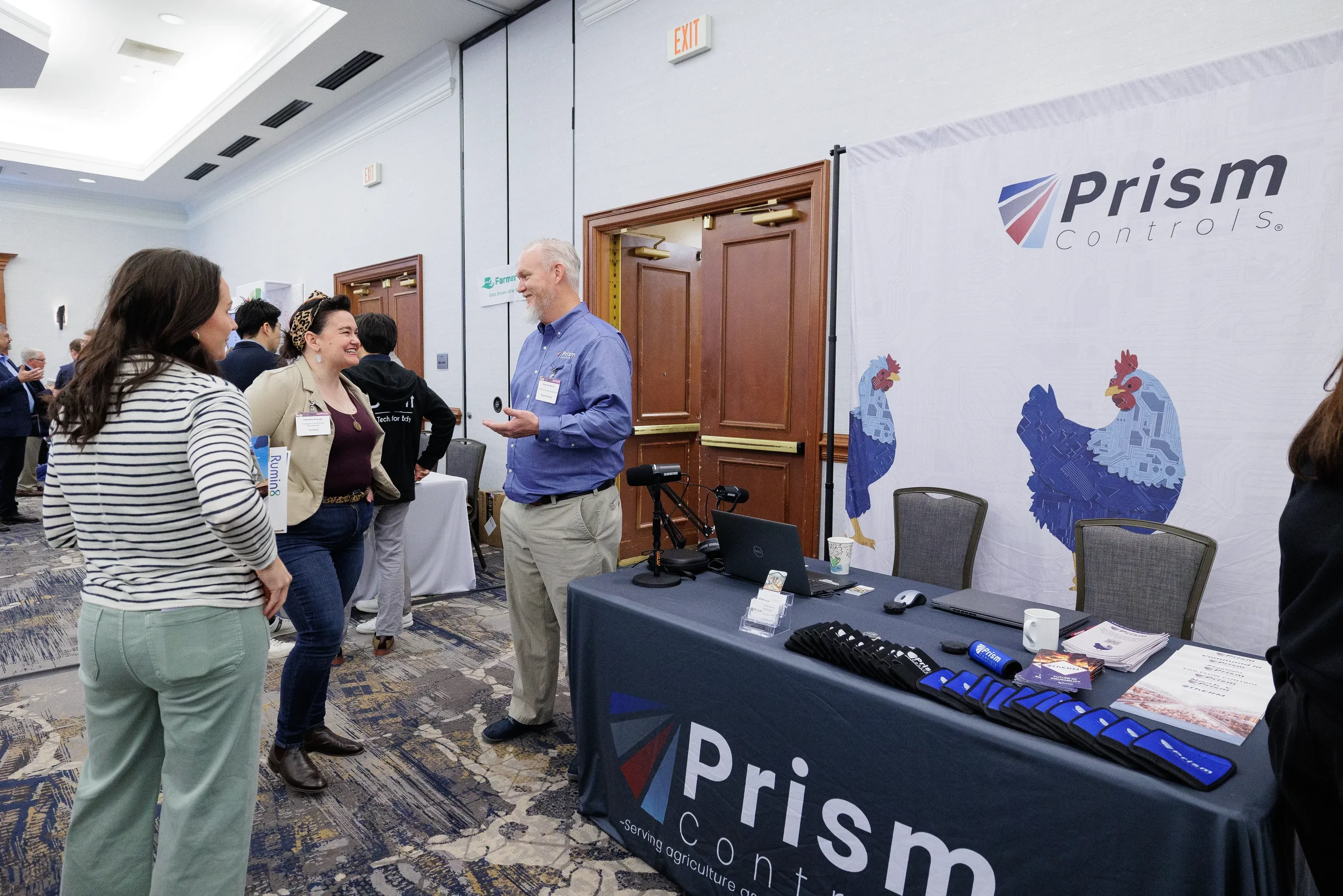 Attendees converse at technology controls expo booth during Chicago trade show