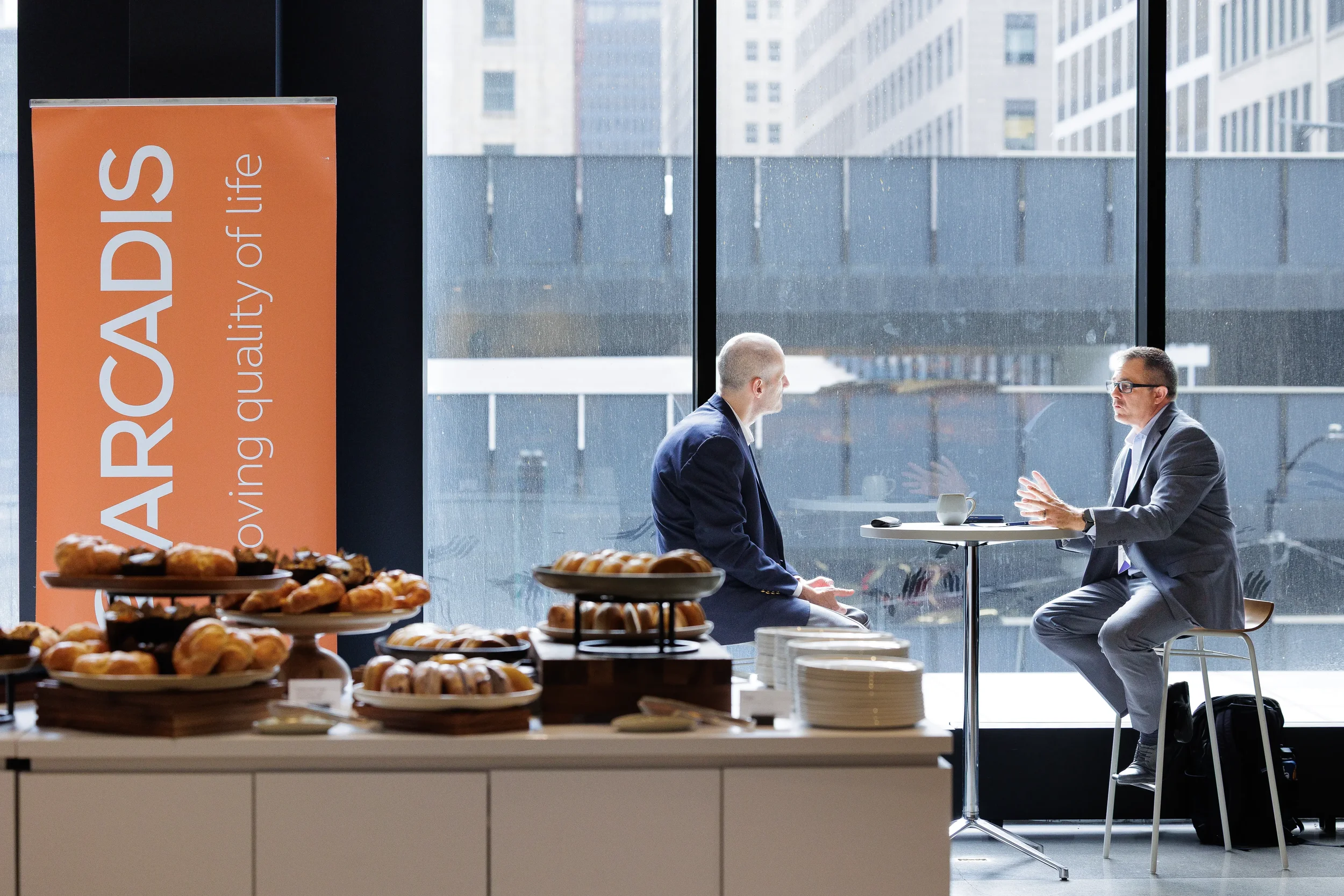 Attendees converse near pastry display during Orlando corporate event reception