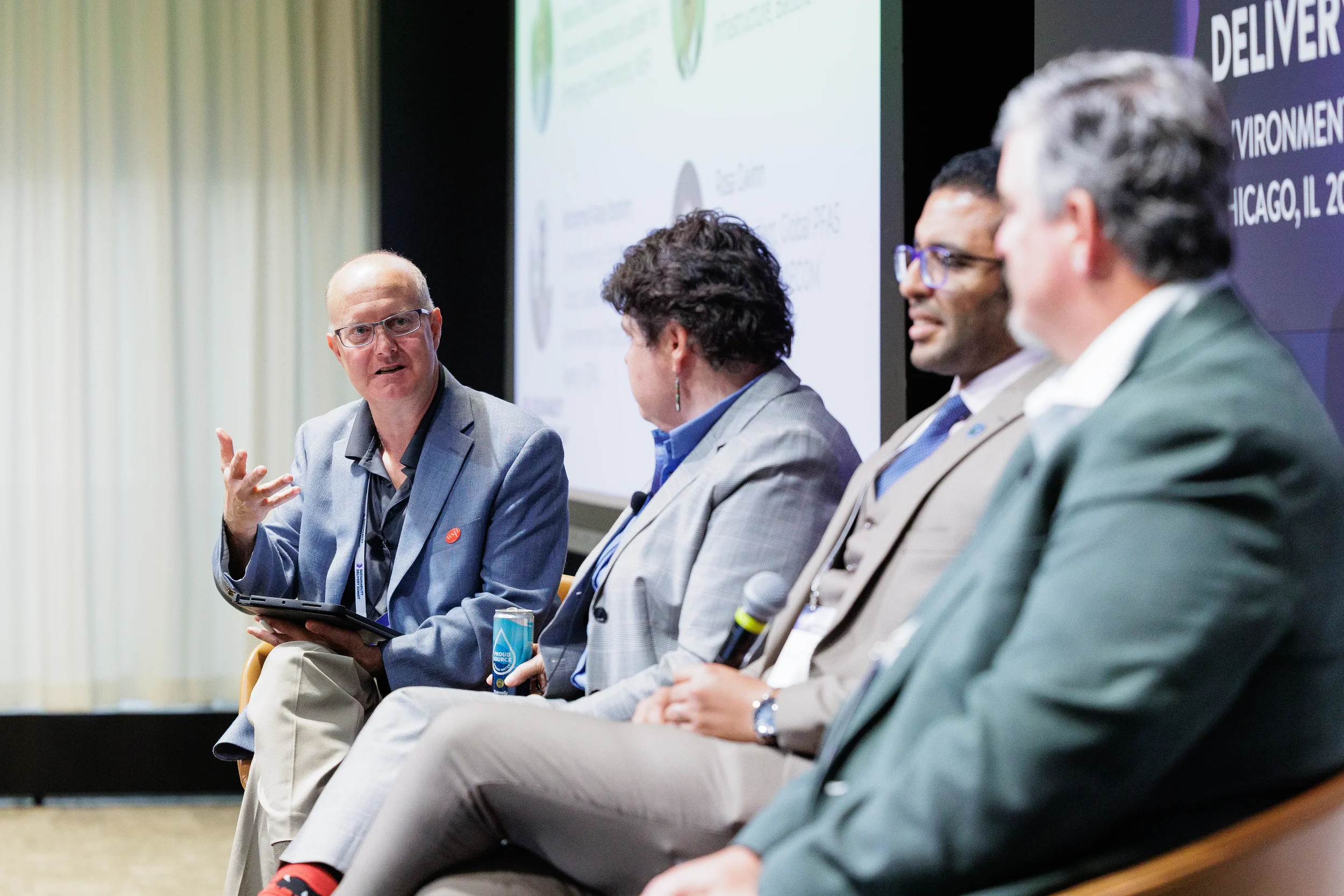 Panelists discuss topics with presentation screen behind them at Orlando industry conference