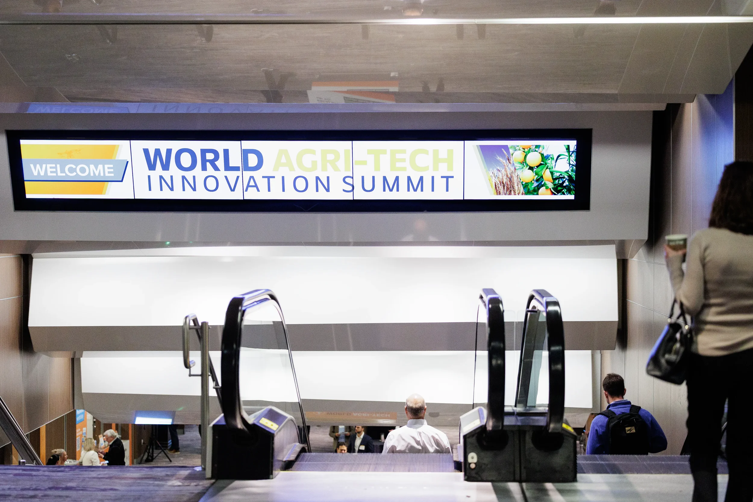 Branded welcome sign displayed above escalators at Orlando industry conference convention center entrance