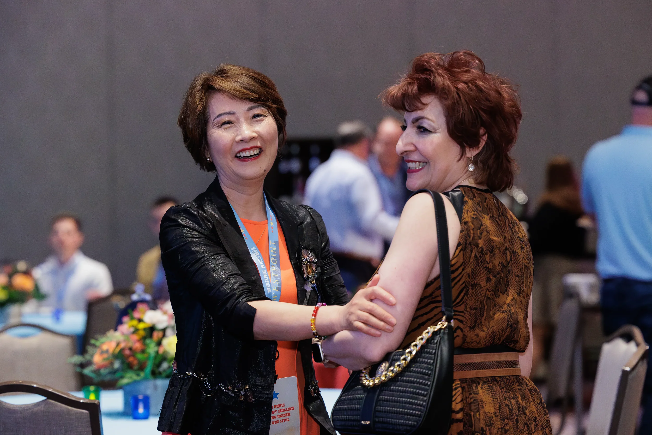 Two attendees laugh together during reception at Orlando corporate conference event