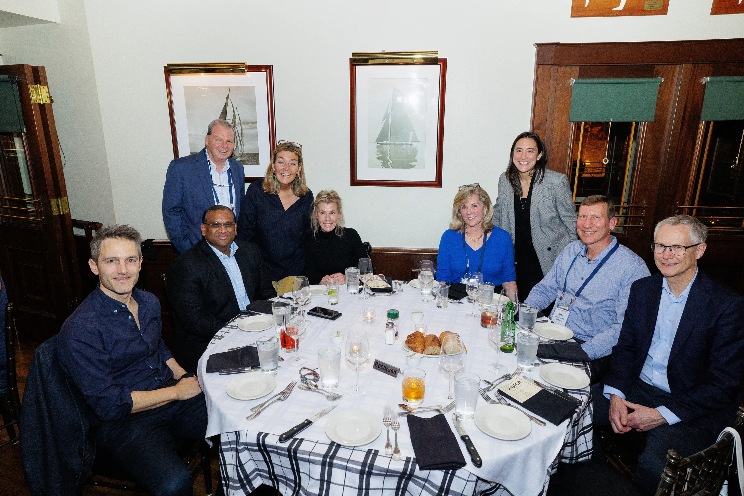 Conference attendees pose for group photo at reserved dinner table during Chicago corporate event