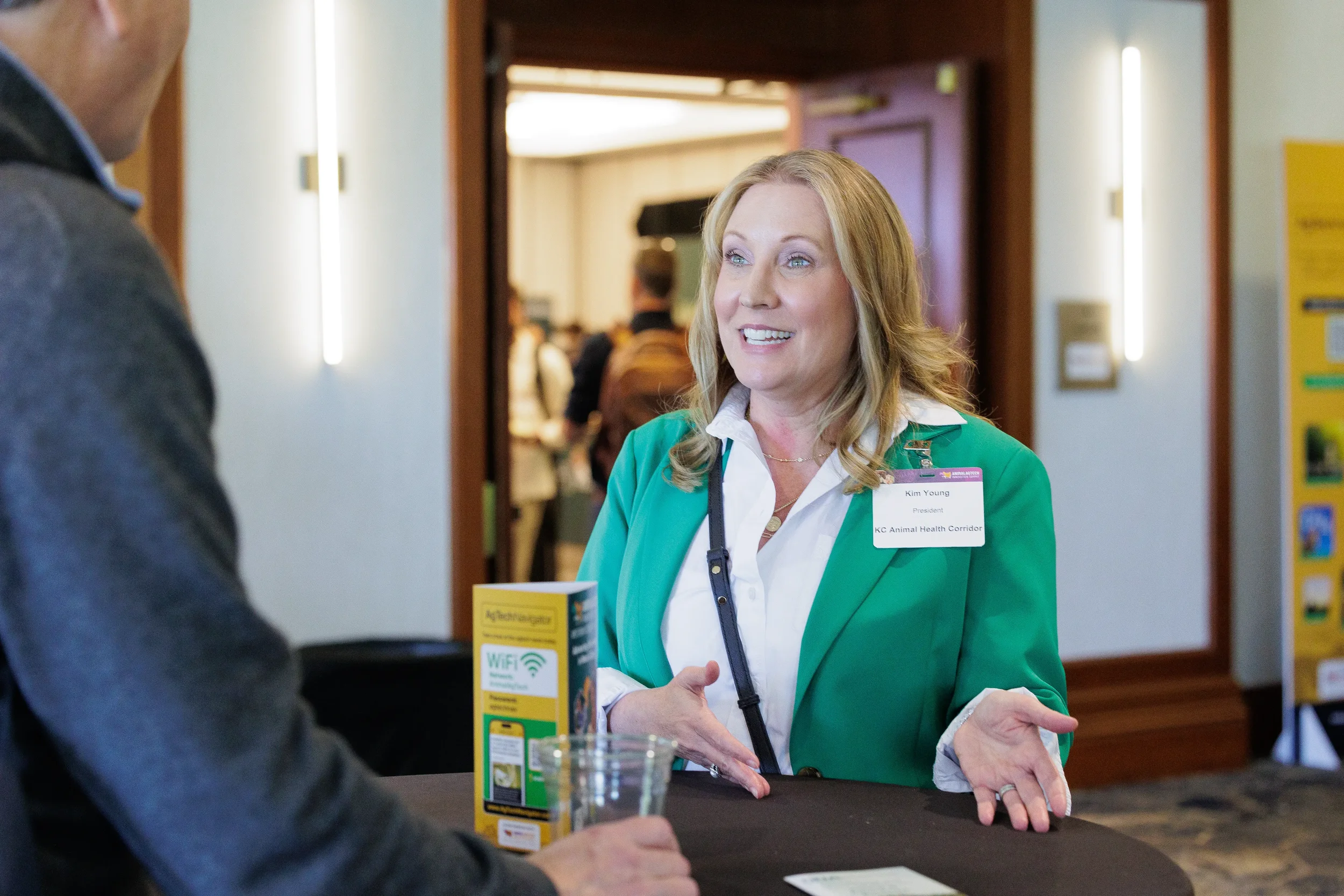 Attendee gestures while conversing in hallway at Chicago corporate conference