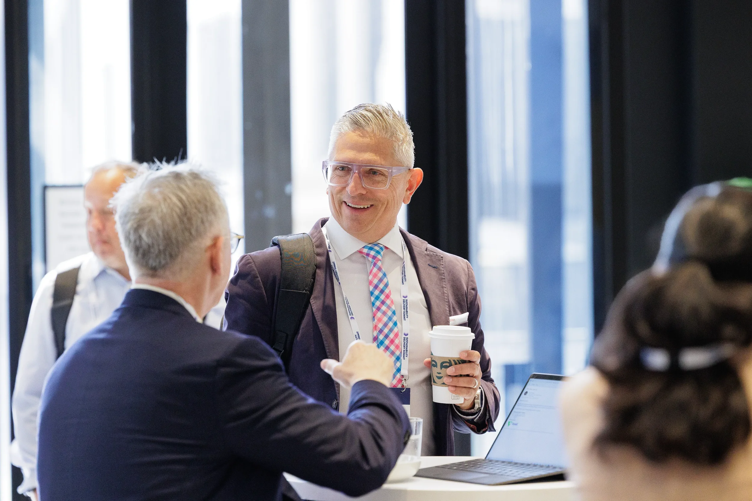 Attendees chat and network with coffee in hand at Orlando corporate conference lobby