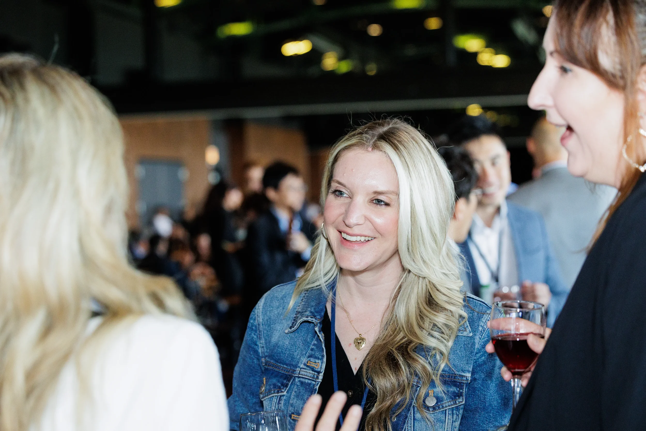 Attendee smiles while conversing with colleagues at Chicago evening reception