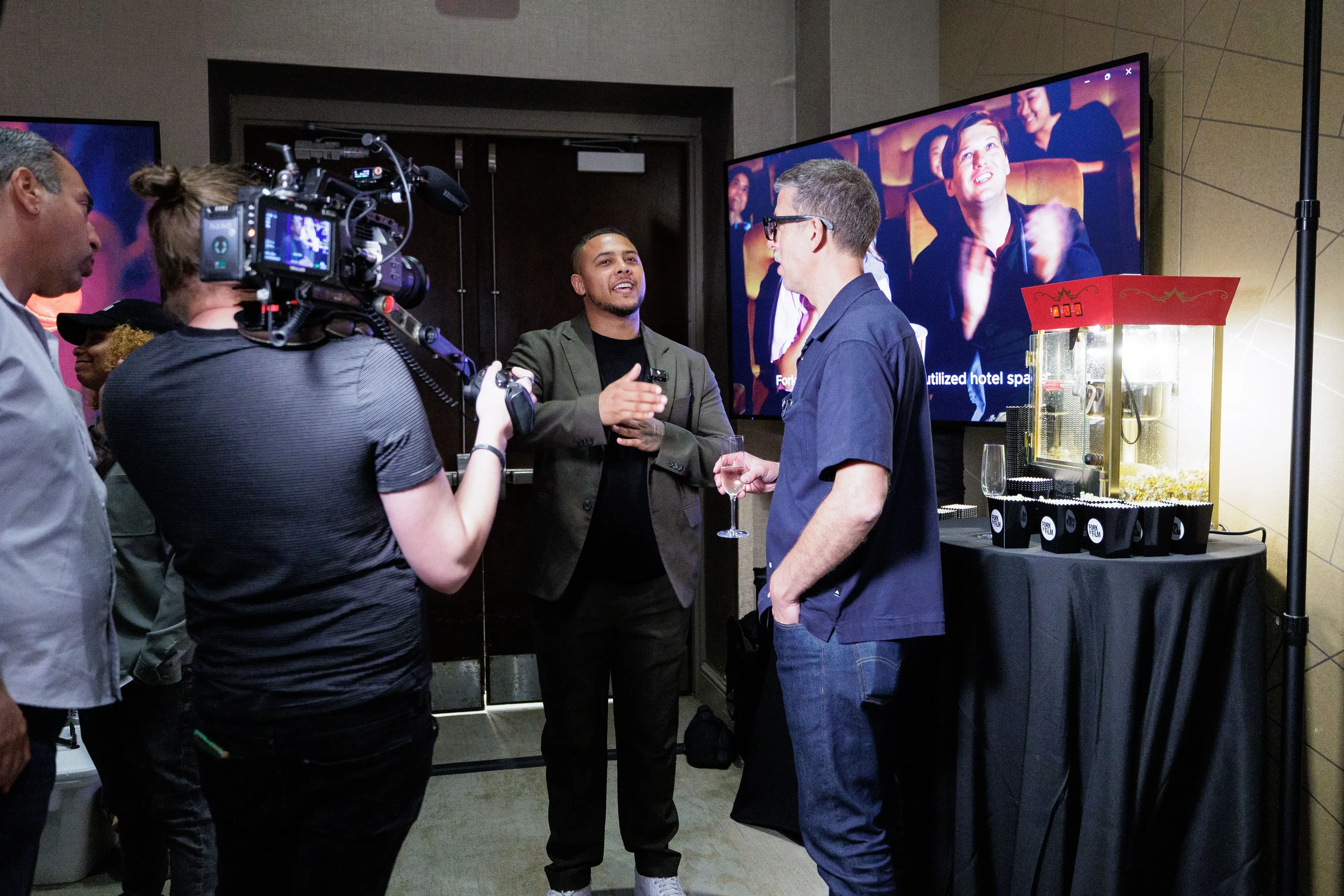 Video crew films attendee interview near popcorn machine at Orlando corporate networking event