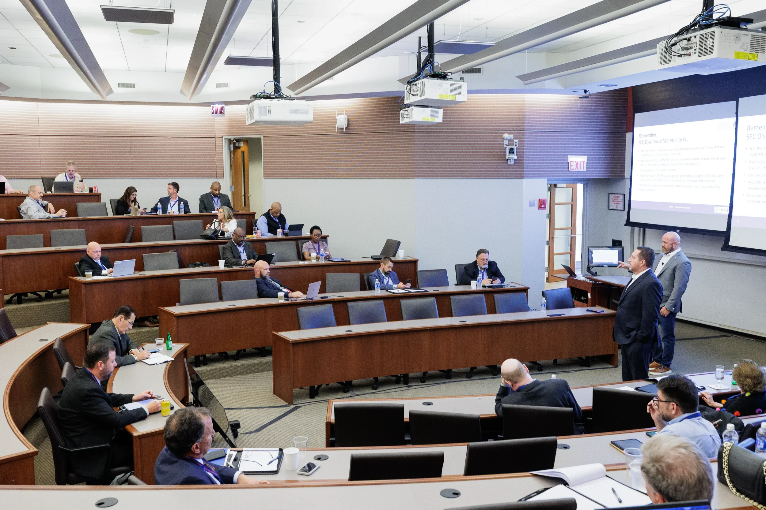 Attendees seated in tiered lecture hall during corporate conference session in Chicago with presentation screen