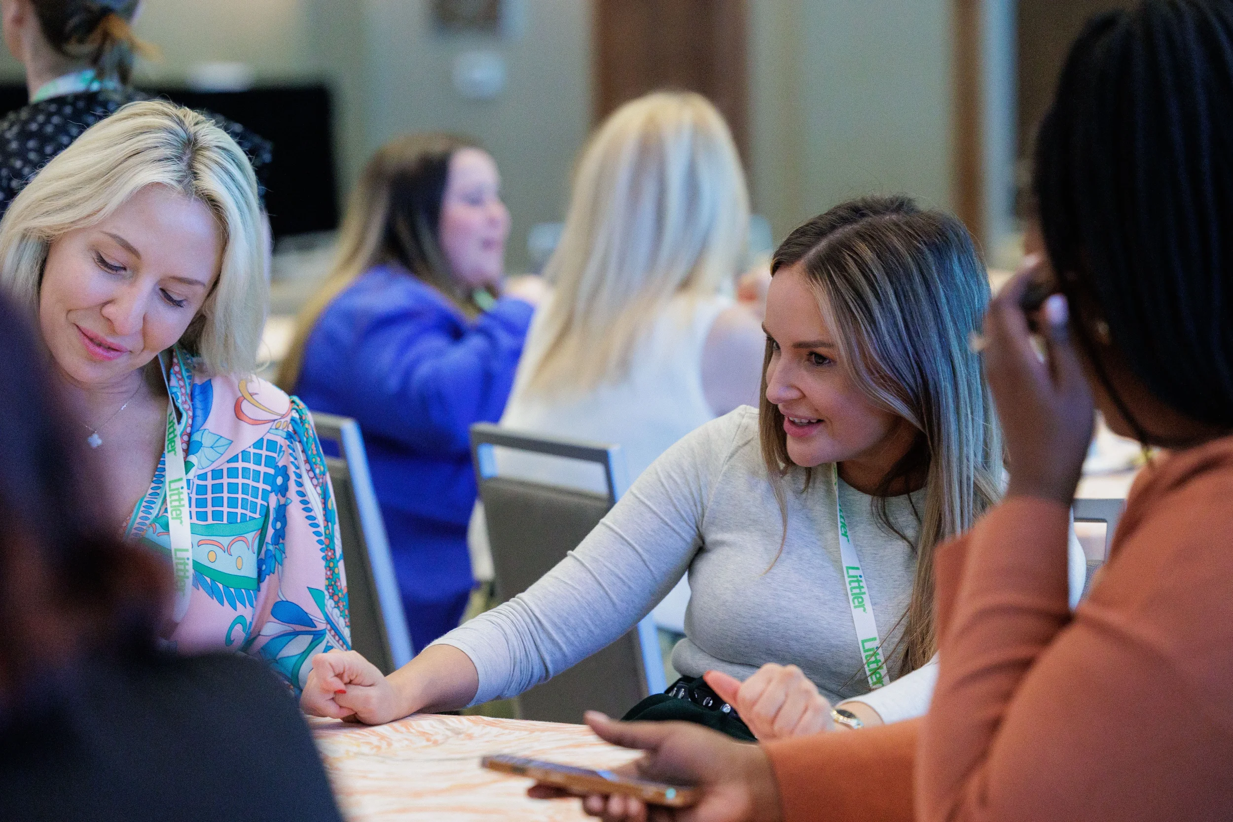 Attendees with lanyards engage in small group discussion at table during Chicago industry conference
