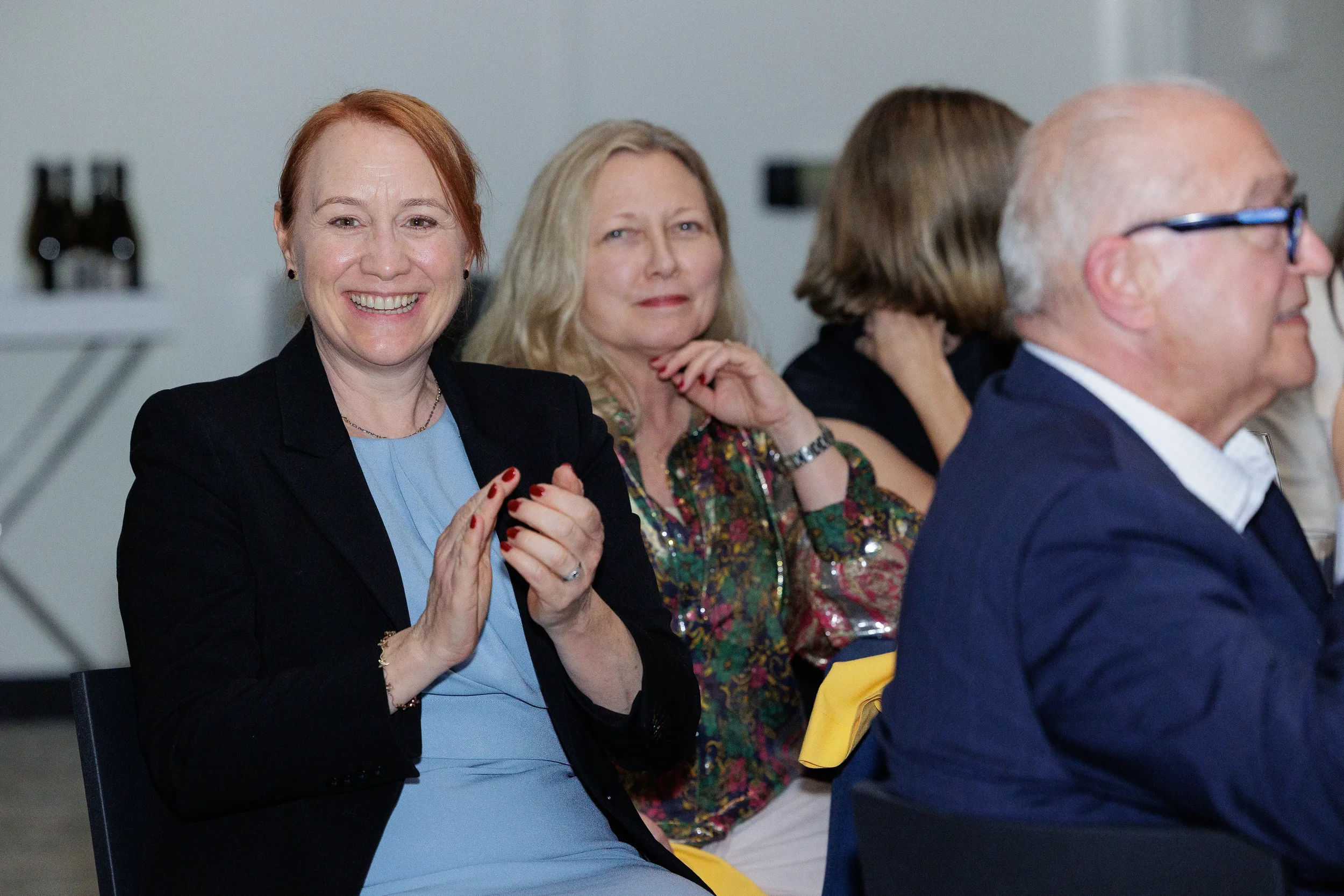 Attendees applaud while seated during session at Chicago corporate conference event