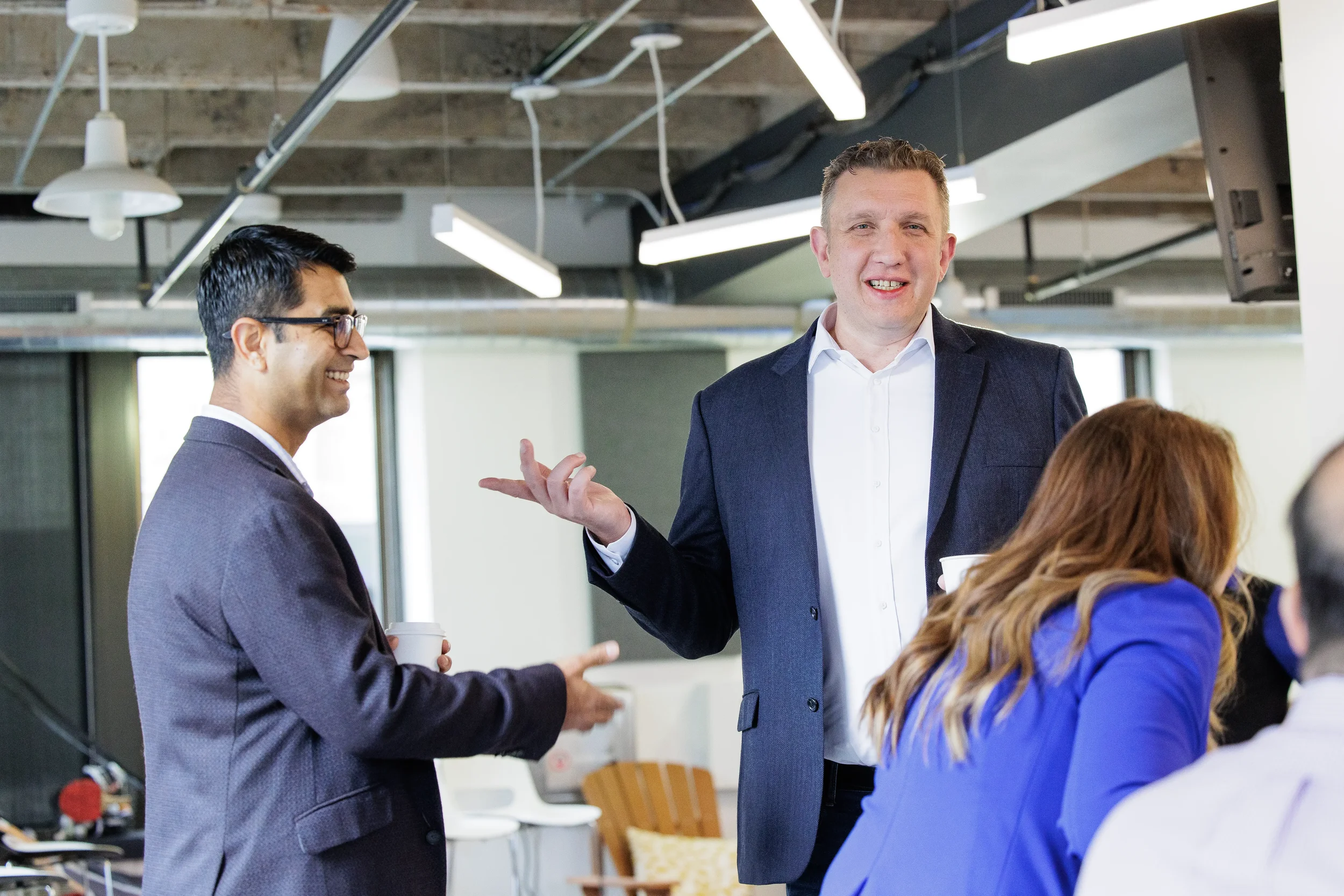 Attendees laugh and converse in groups during a networking break at Orlando corporate event