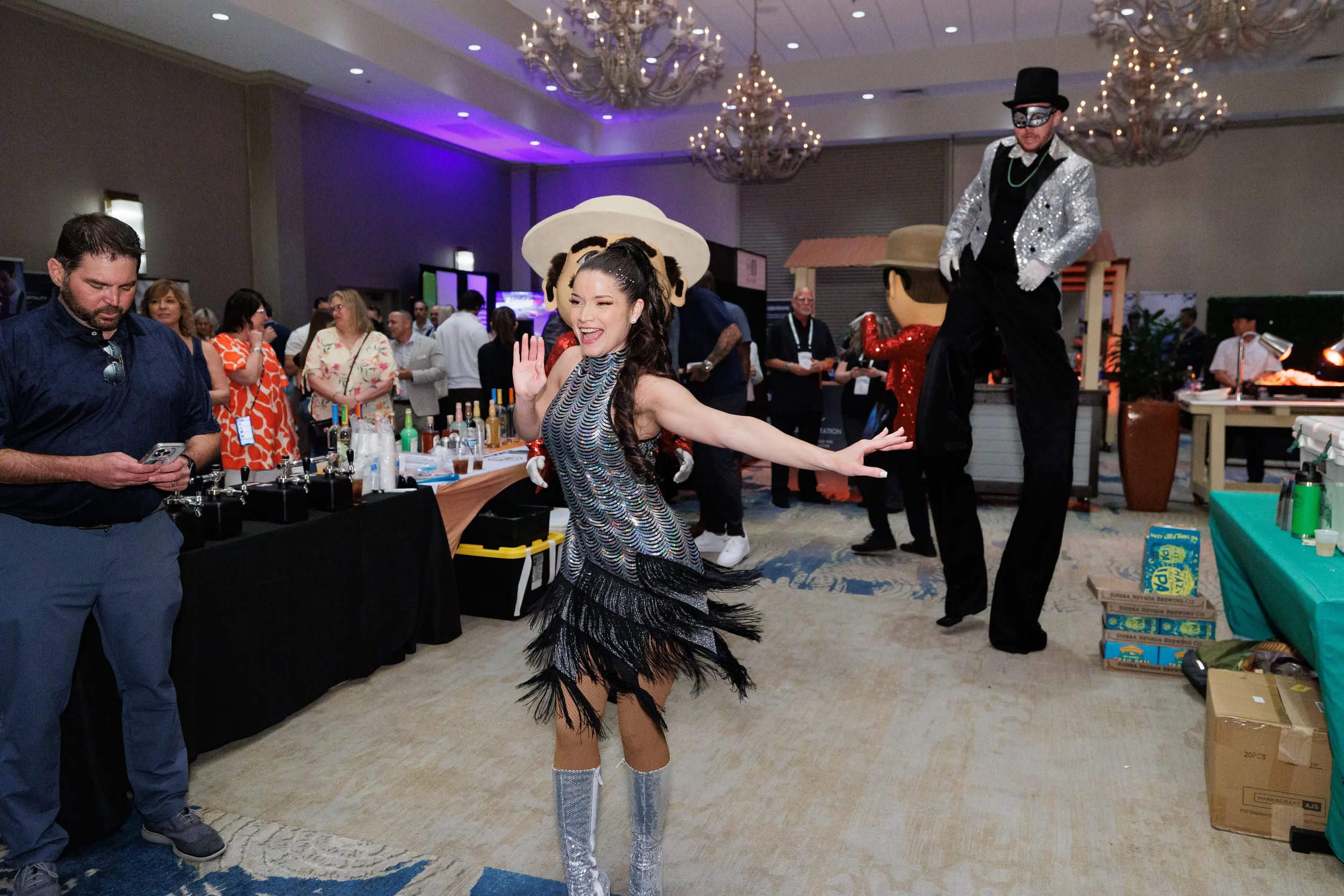 Costumed dancer in sequined fringe dress performs for attendees in chandelier ballroom at Chicago corporate event