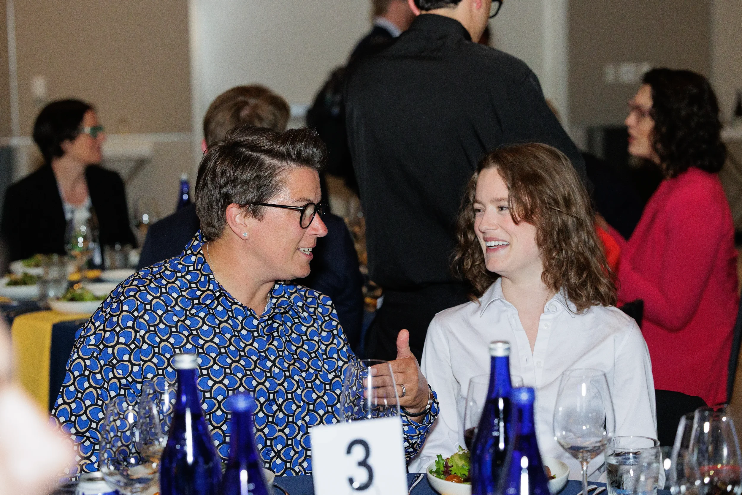 Attendees laugh together during conversation at dinner table at Chicago corporate event