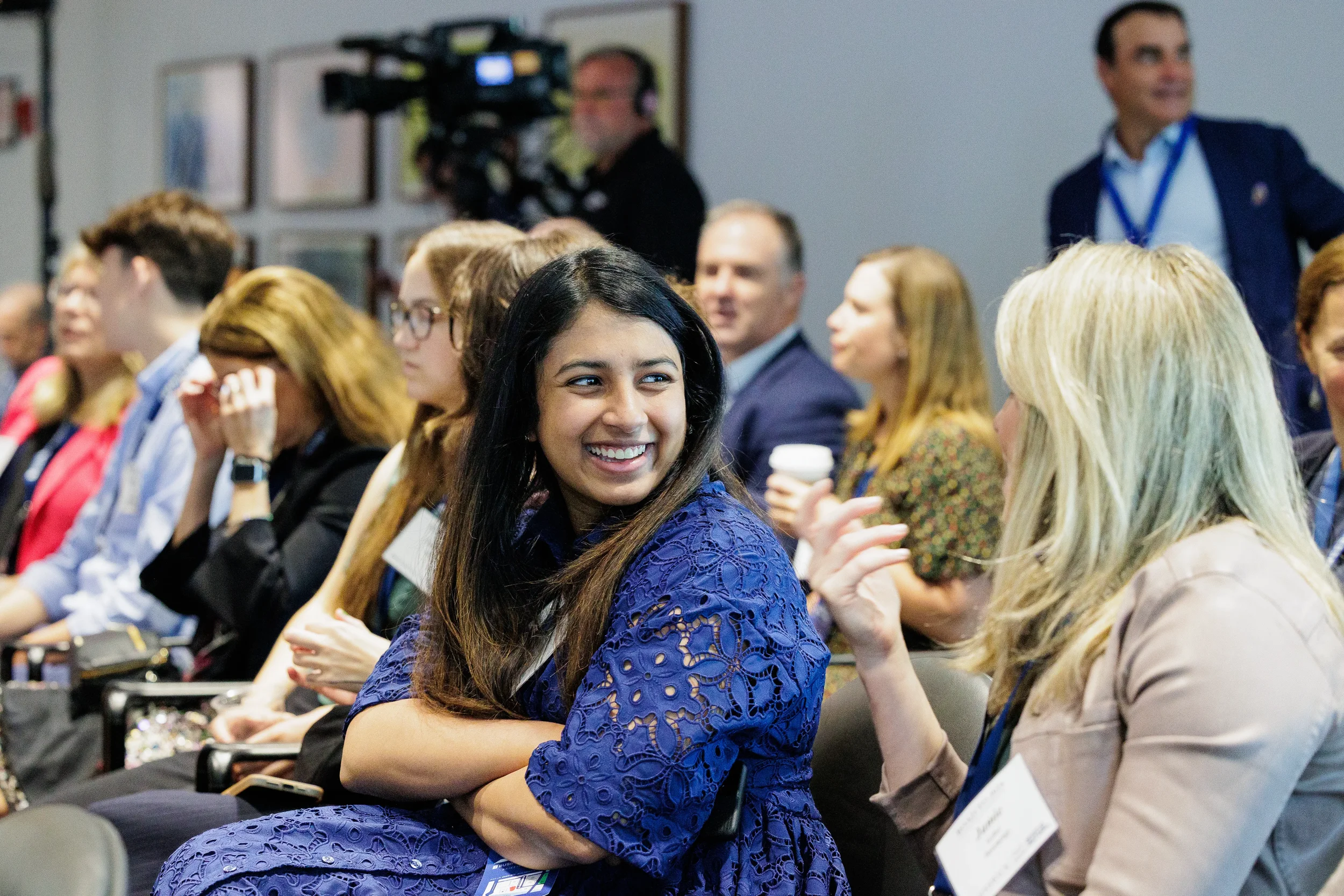 Attendee smiles while turning to talk with neighbor during session at Chicago corporate conference