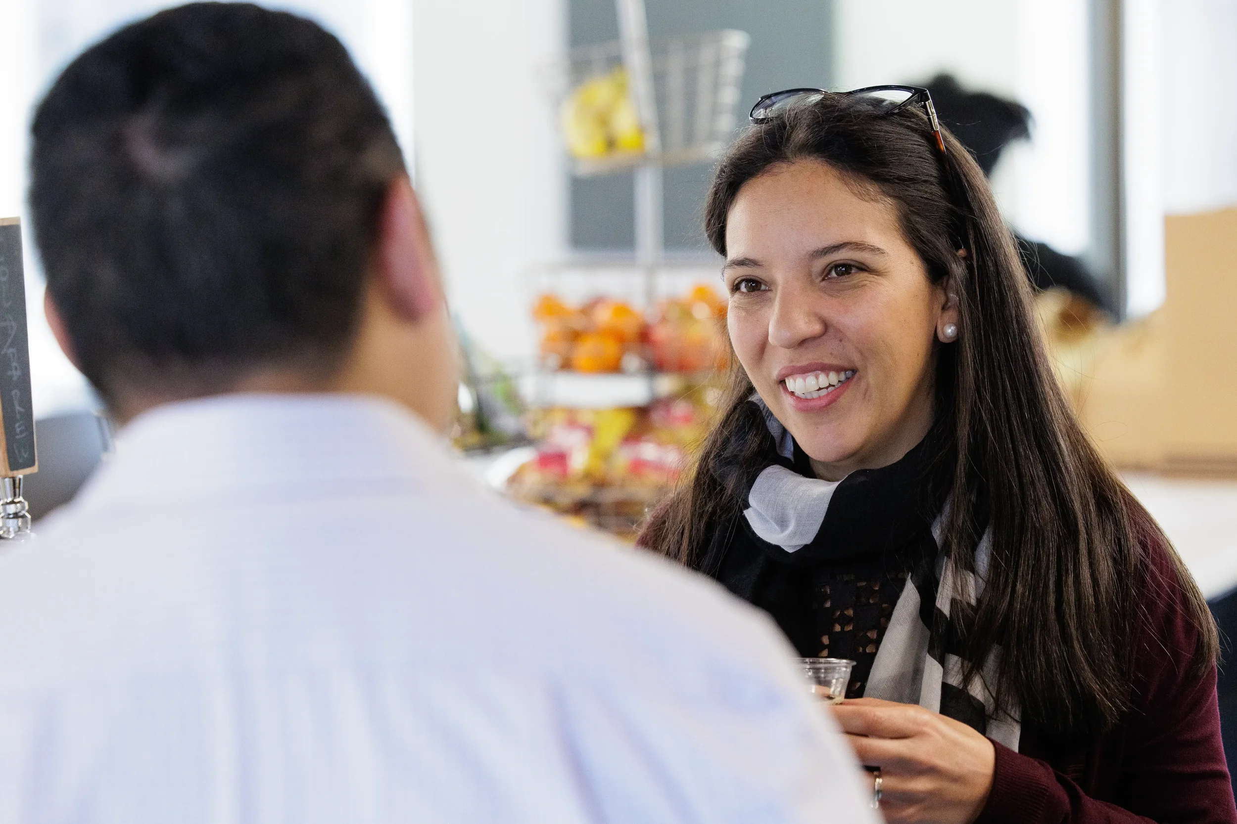 Female attendee smiles warmly across a table during a conversation at Orlando industry conference