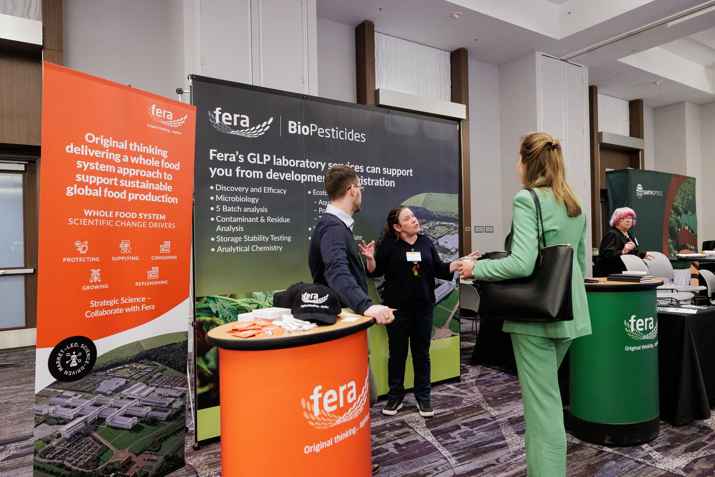 Attendees speak with exhibitor staff at trade show booth during Chicago industry conference expo