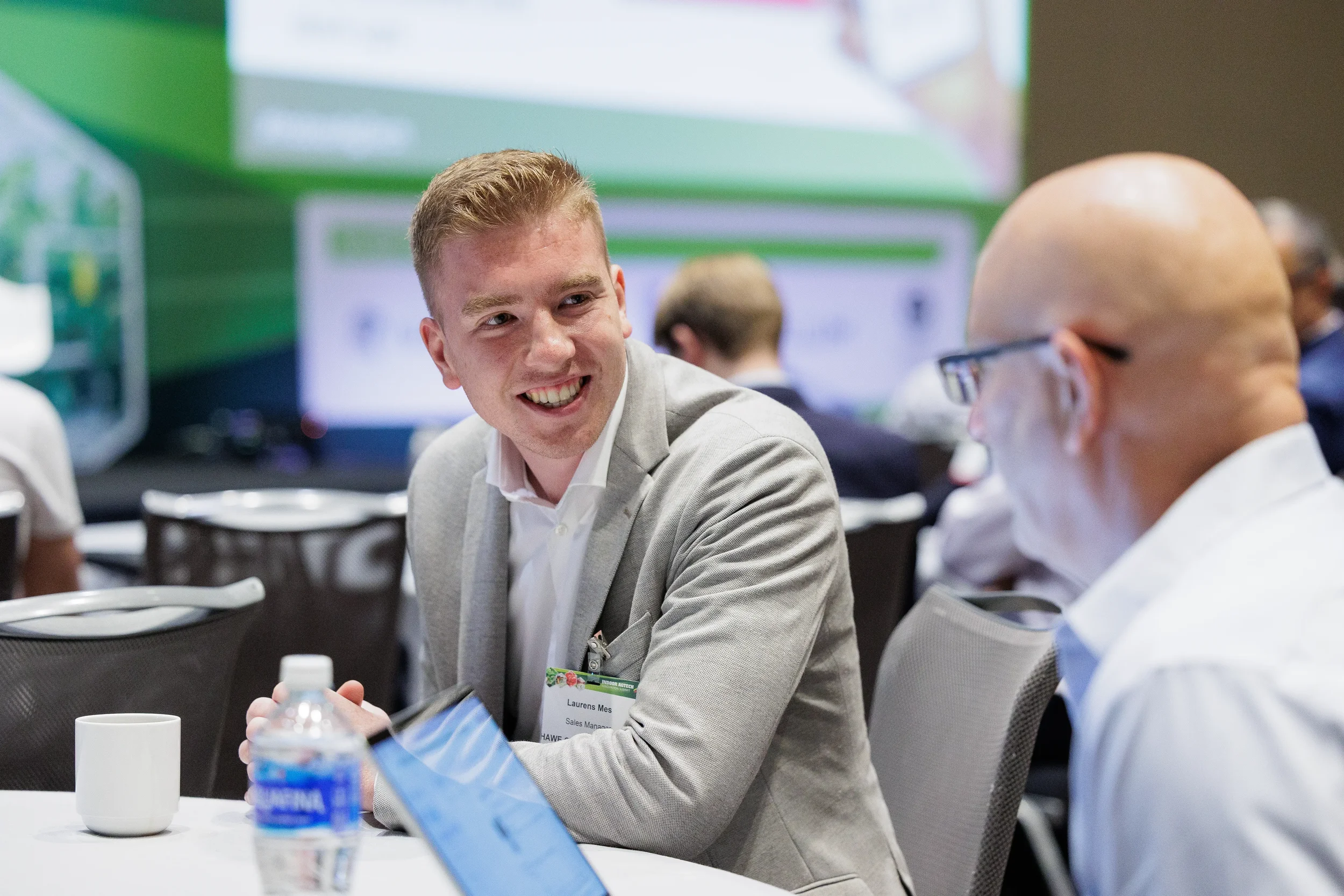 Attendee smiles while engaged in conversation at round table during Orlando industry conference event