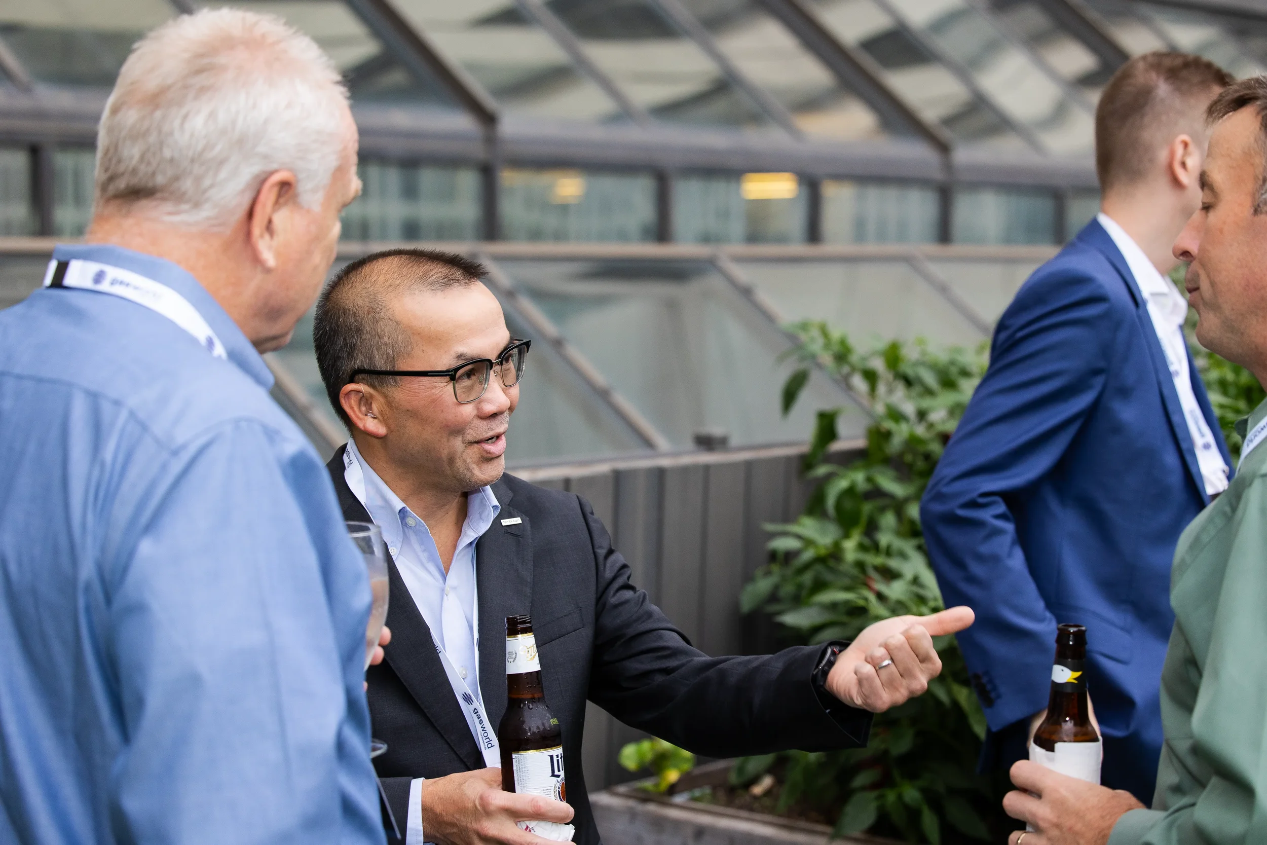 Attendees network over drinks in glass-roofed atrium during Chicago corporate summit reception