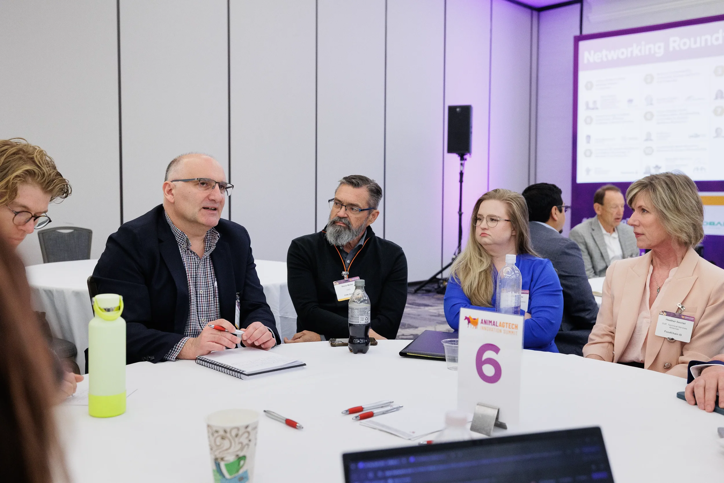 Attendees engage in roundtable discussion during networking session at Orlando conference