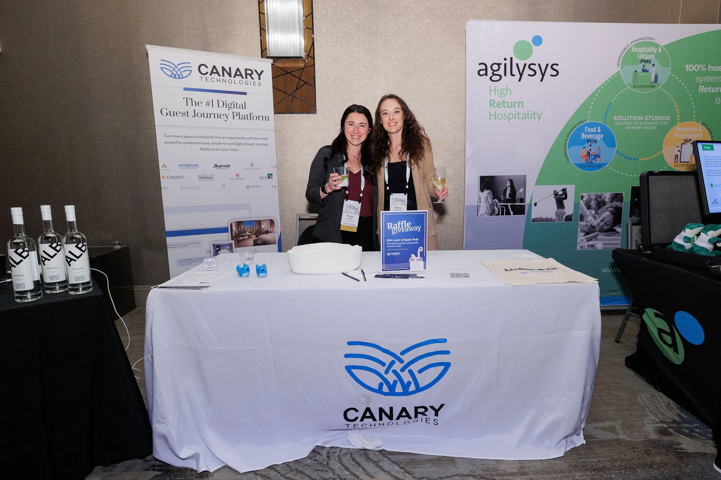 Two exhibitors smile together behind branded table at Chicago corporate conference trade show
