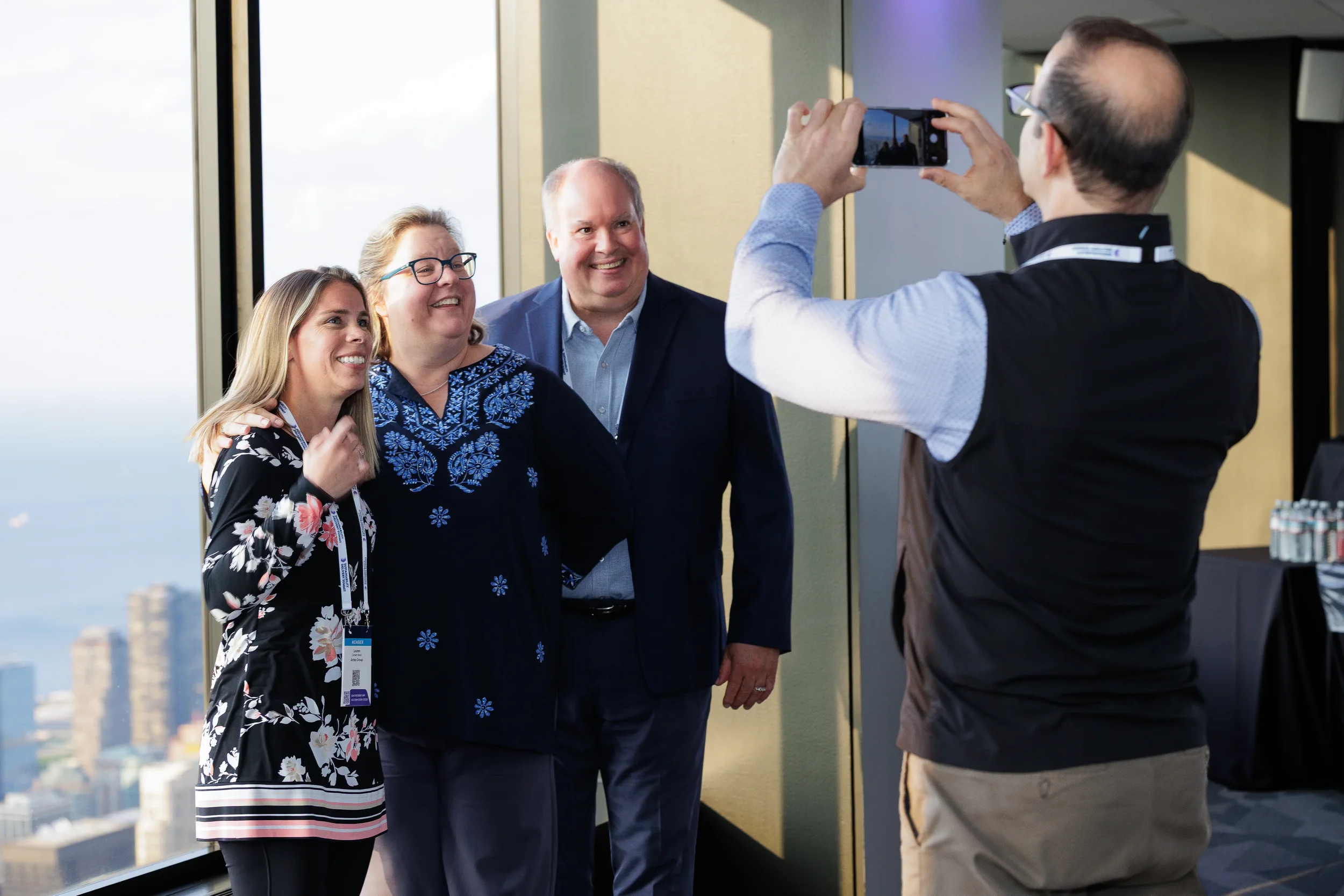 Attendees pose for a photo with skyline view during Chicago corporate conference reception