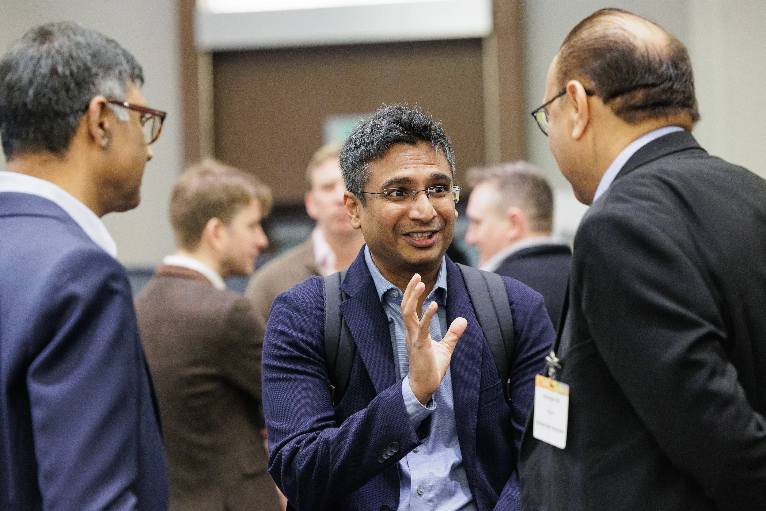 Attendee gestures while networking with colleagues at Orlando industry conference