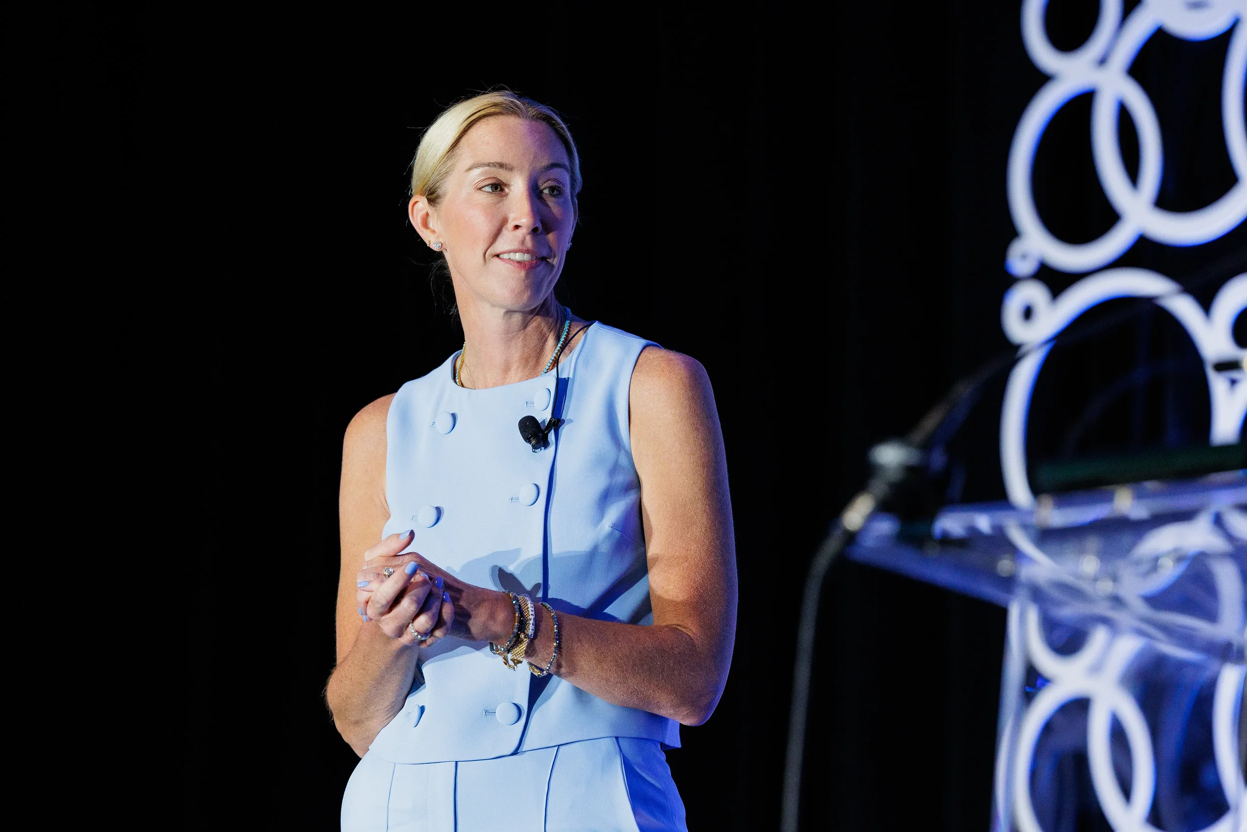 Speaker gestures while addressing audience on stage at Chicago corporate conference