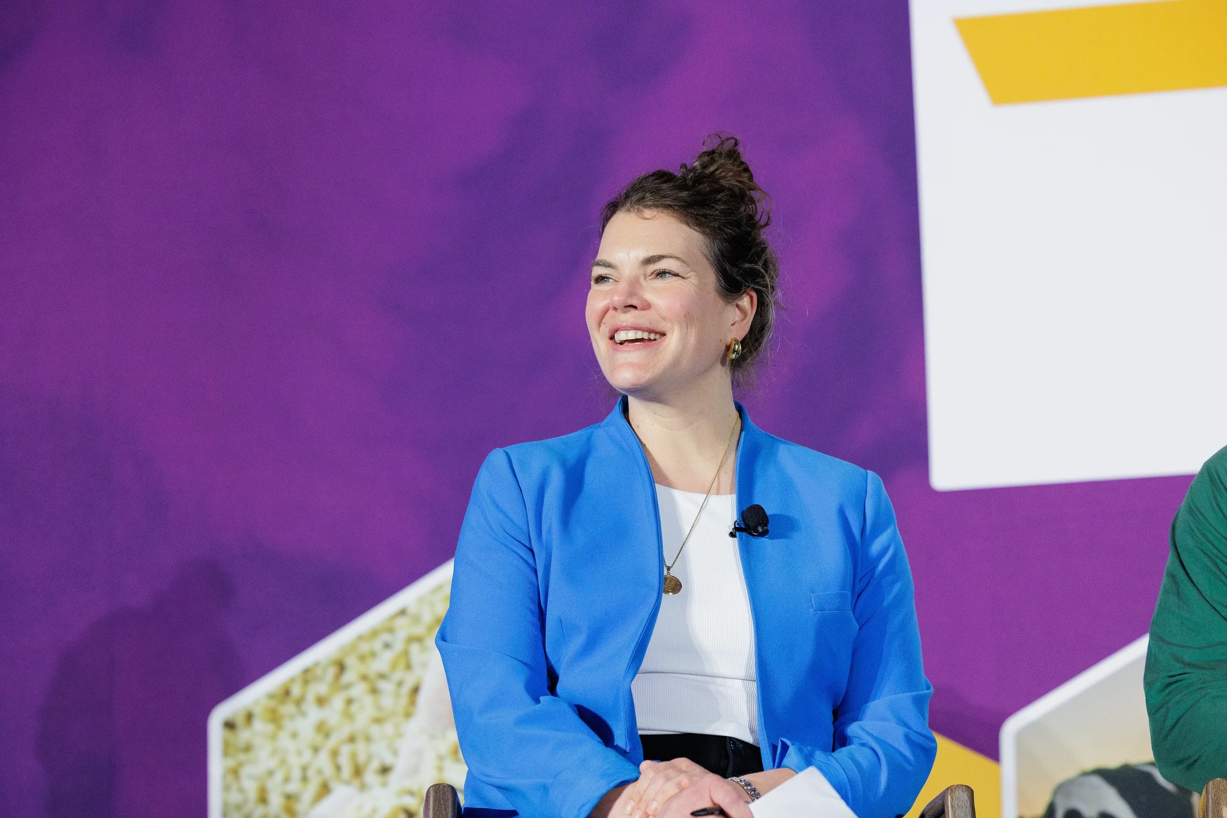 Speaker smiles on branded stage during session at Chicago industry summit