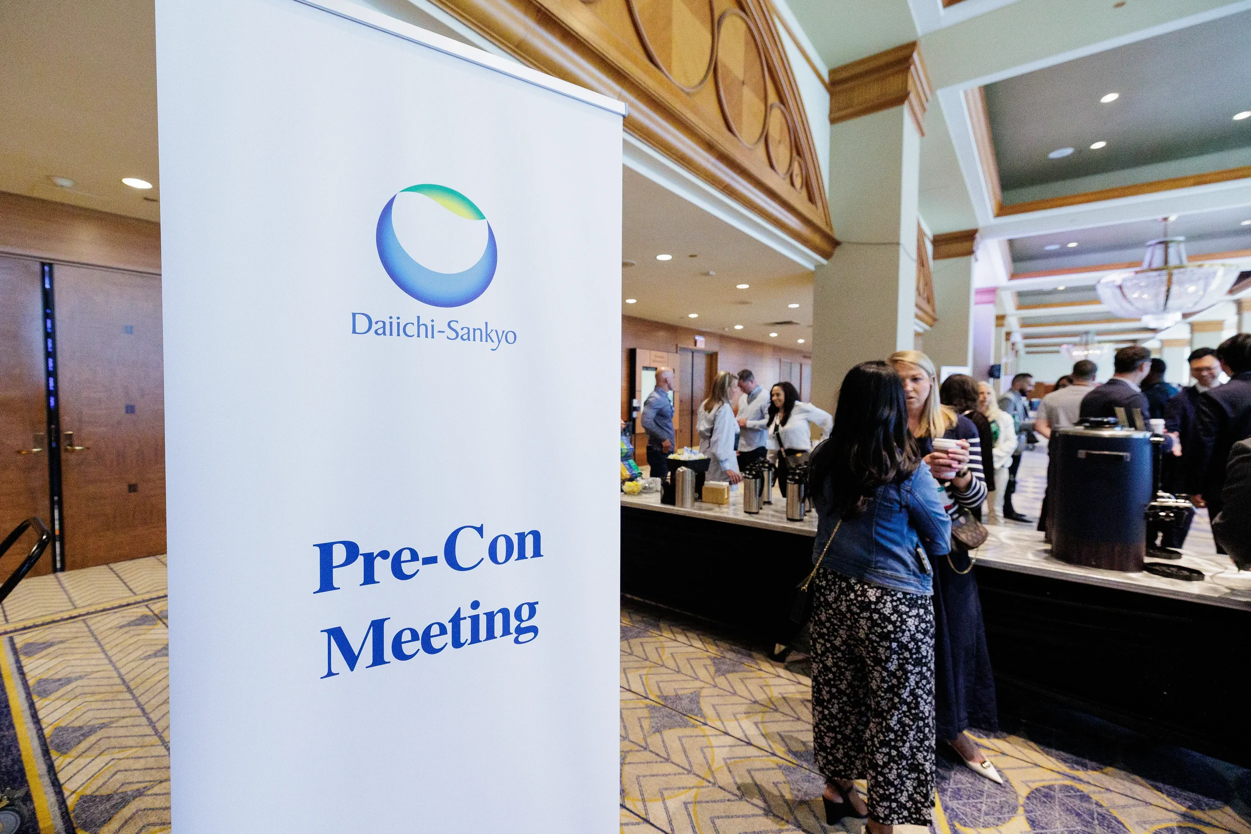 Attendees gather near coffee station beside conference signage at Chicago corporate event