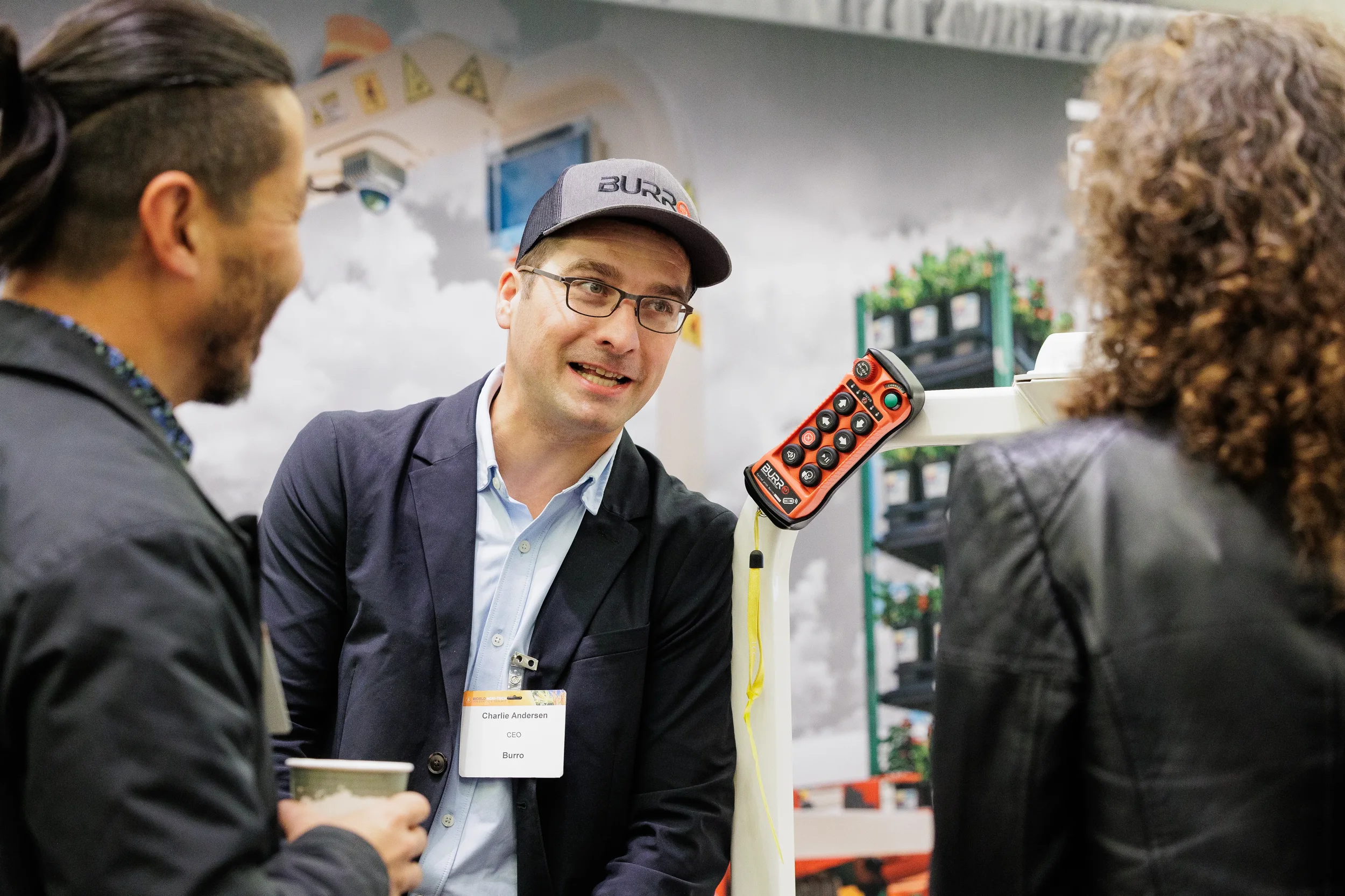 Exhibitor with name badge engages attendees in conversation at trade show booth at Orlando corporate conference
