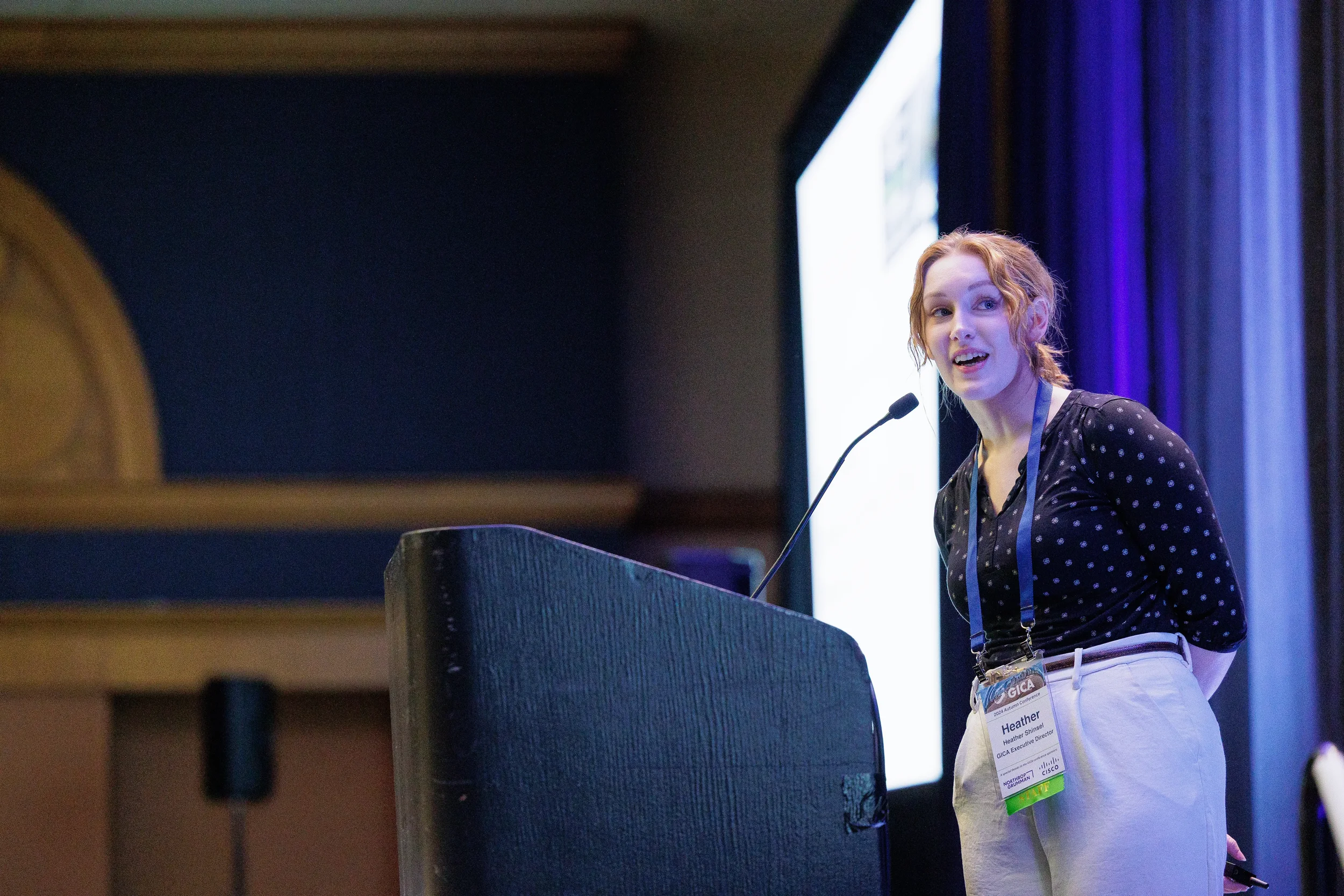 Conference speaker addresses audience from podium on stage at Orlando corporate event