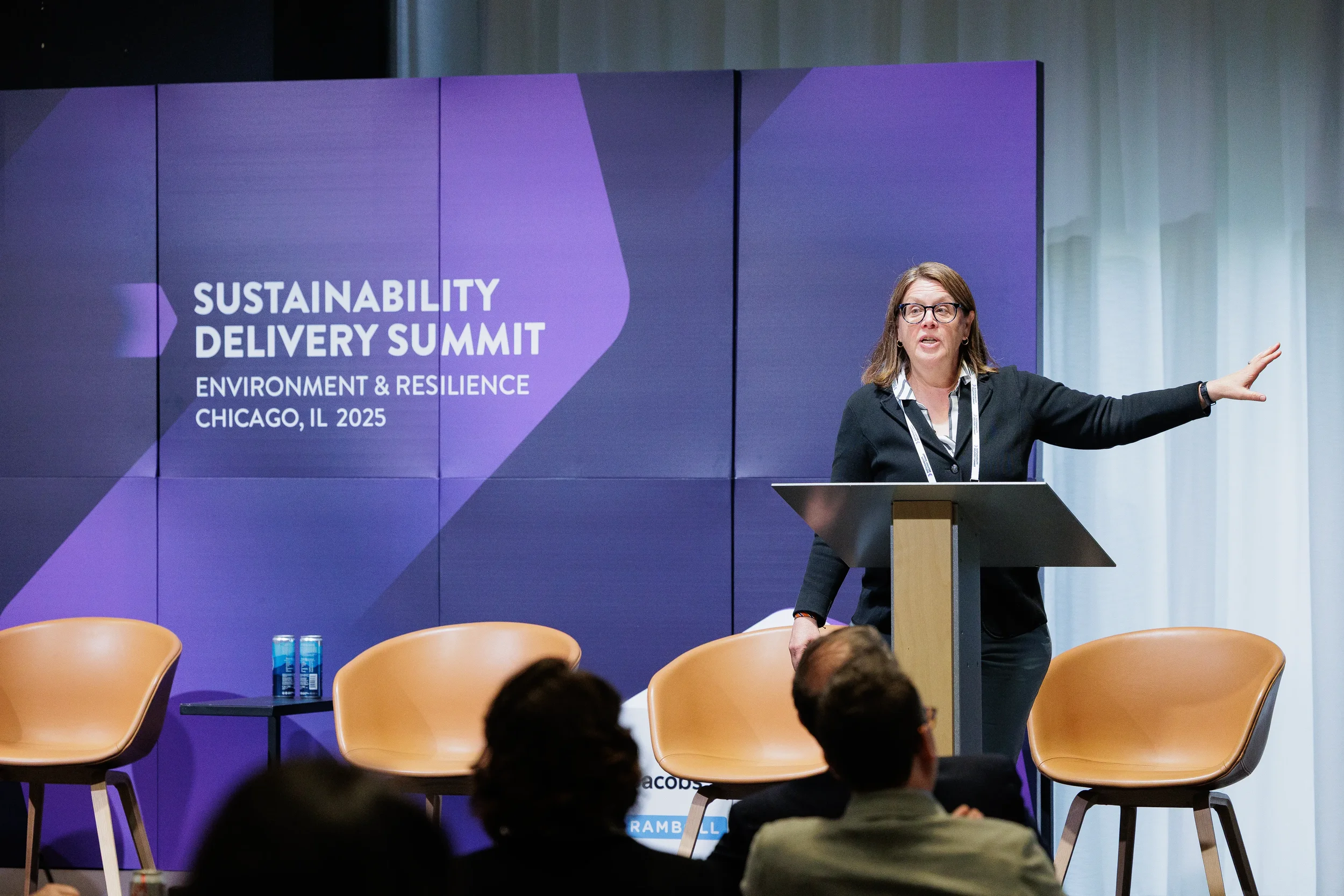 Speaker gestures while presenting from podium on branded stage at Orlando industry summit