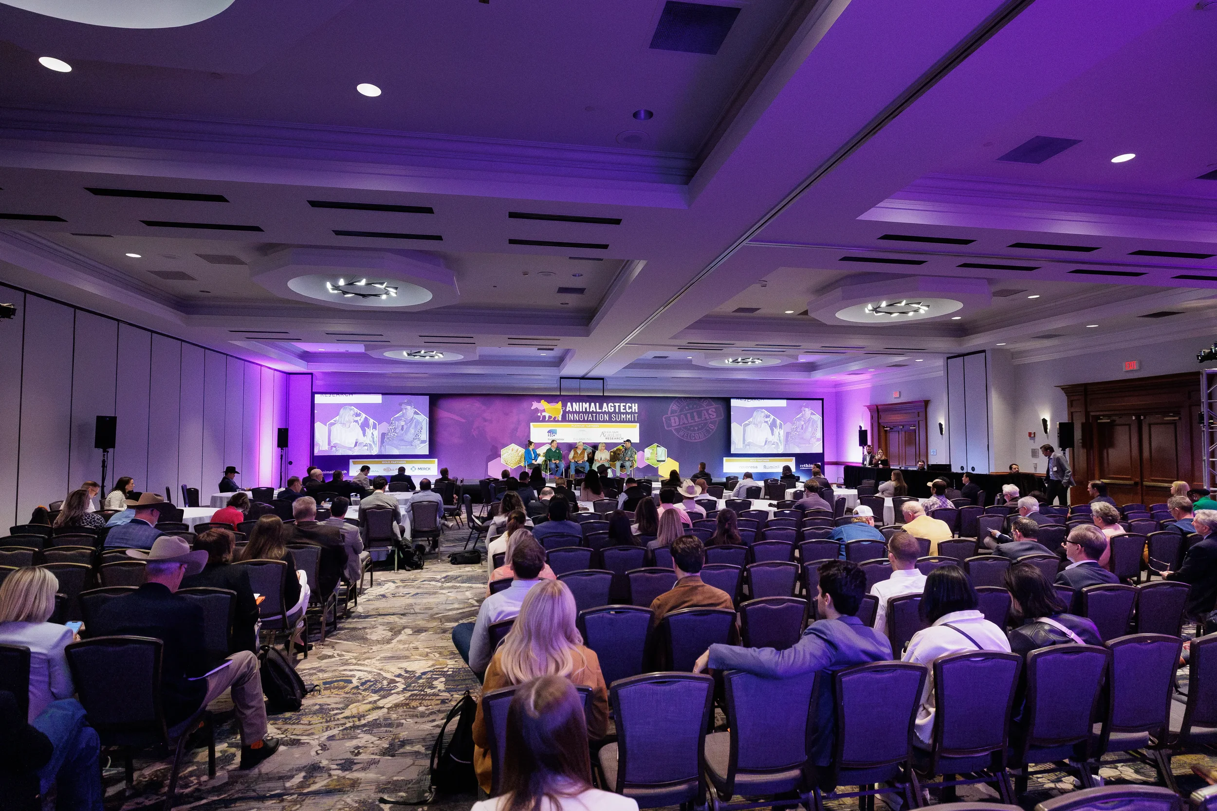 Wide view of ballroom audience watching panel discussion on stage at Chicago corporate summit