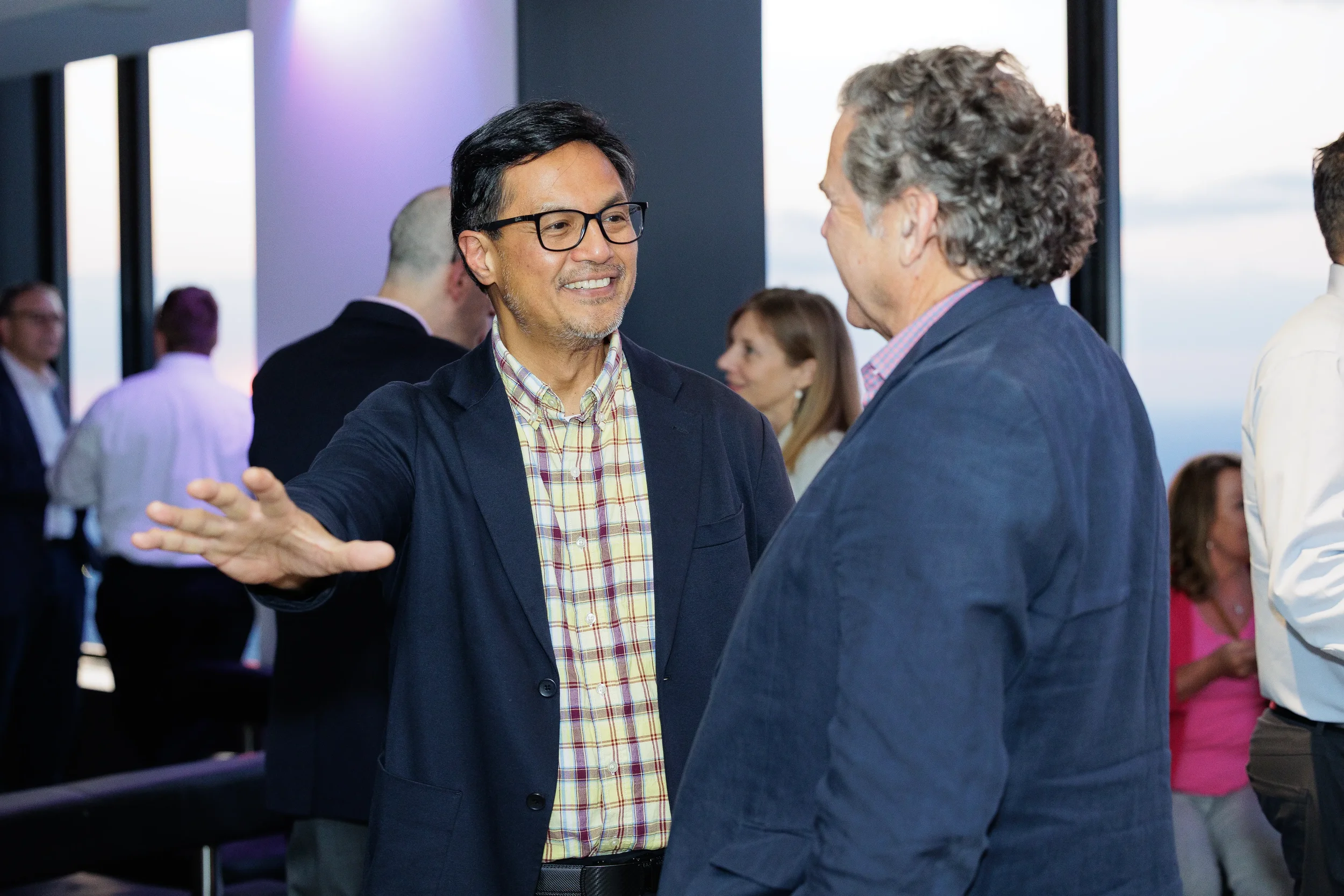 Attendees network with skyline view in background at Chicago corporate event reception