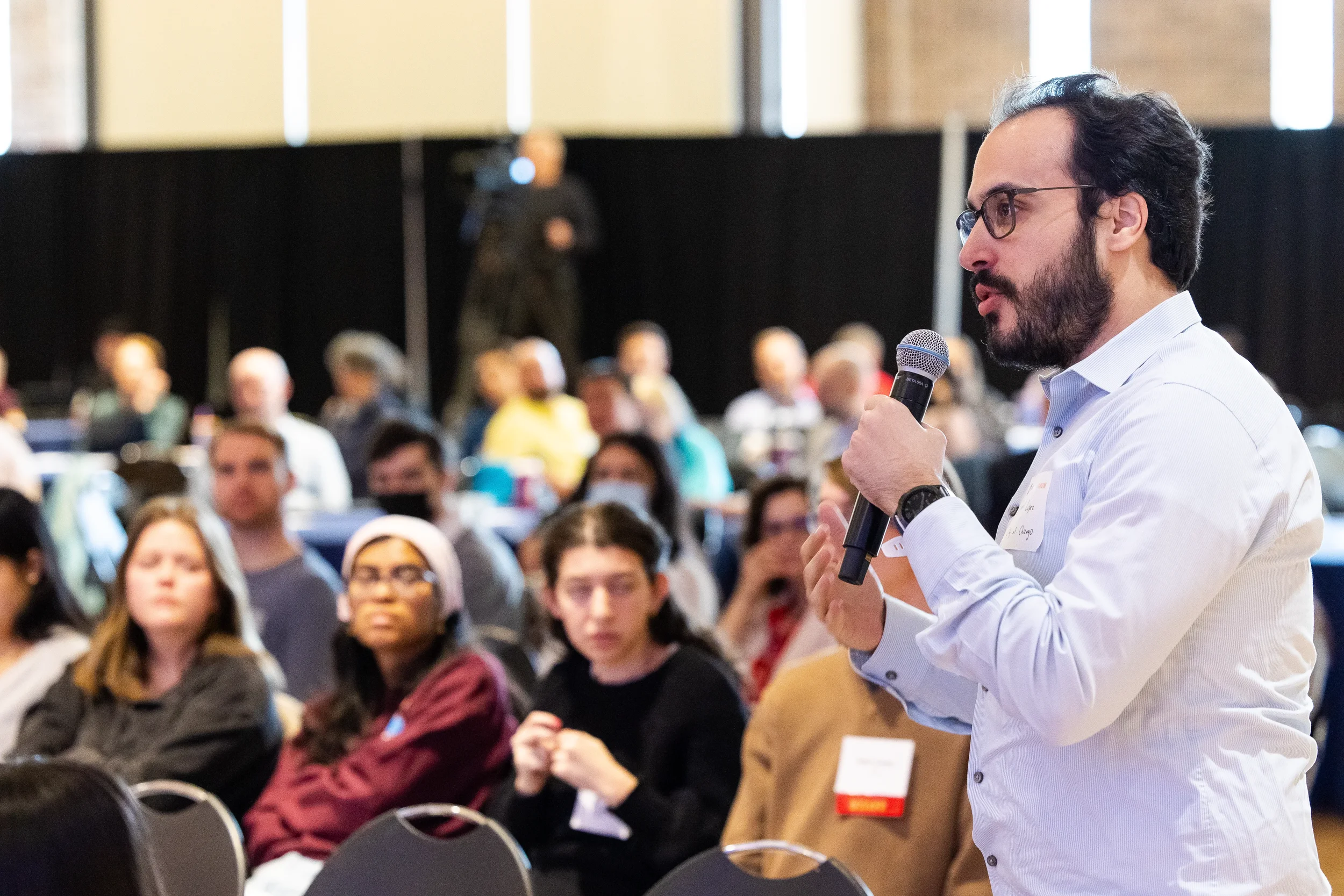 Attendee stands and speaks into microphone during audience Q&A at Orlando corporate event
