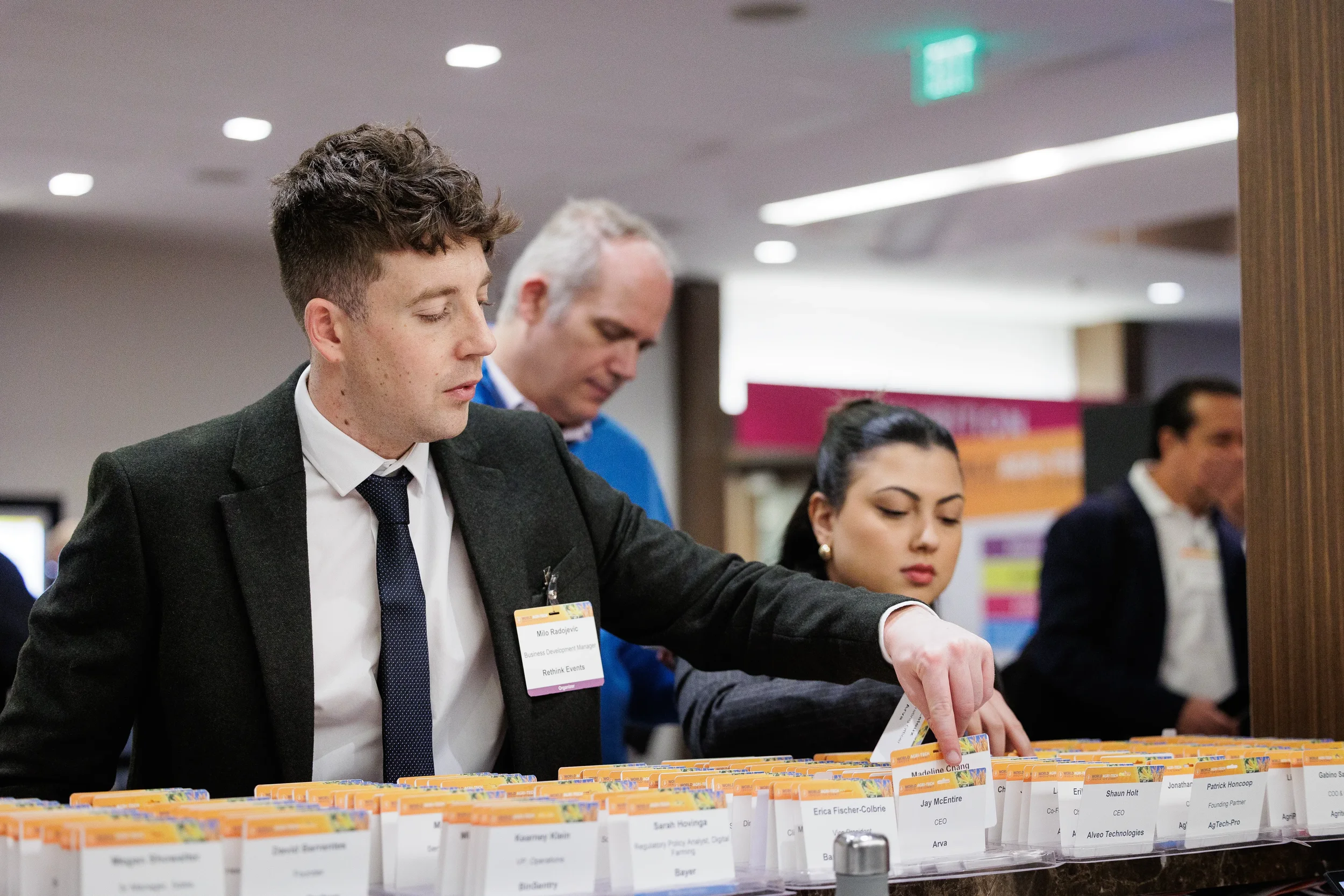 Attendees organize name badges at registration table during Orlando corporate event