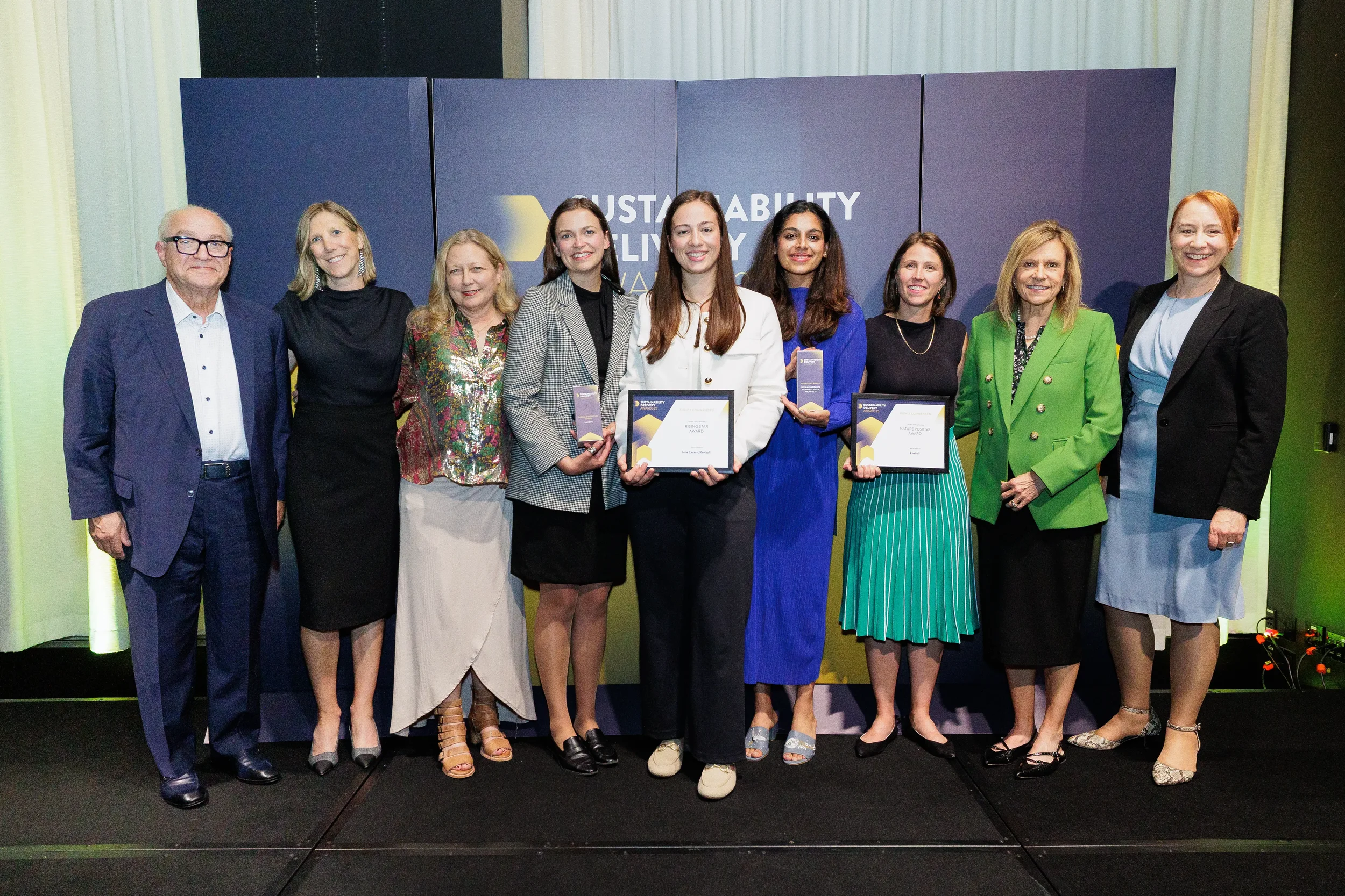 Group of award recipients pose with certificates in front of branded backdrop at Chicago ceremony