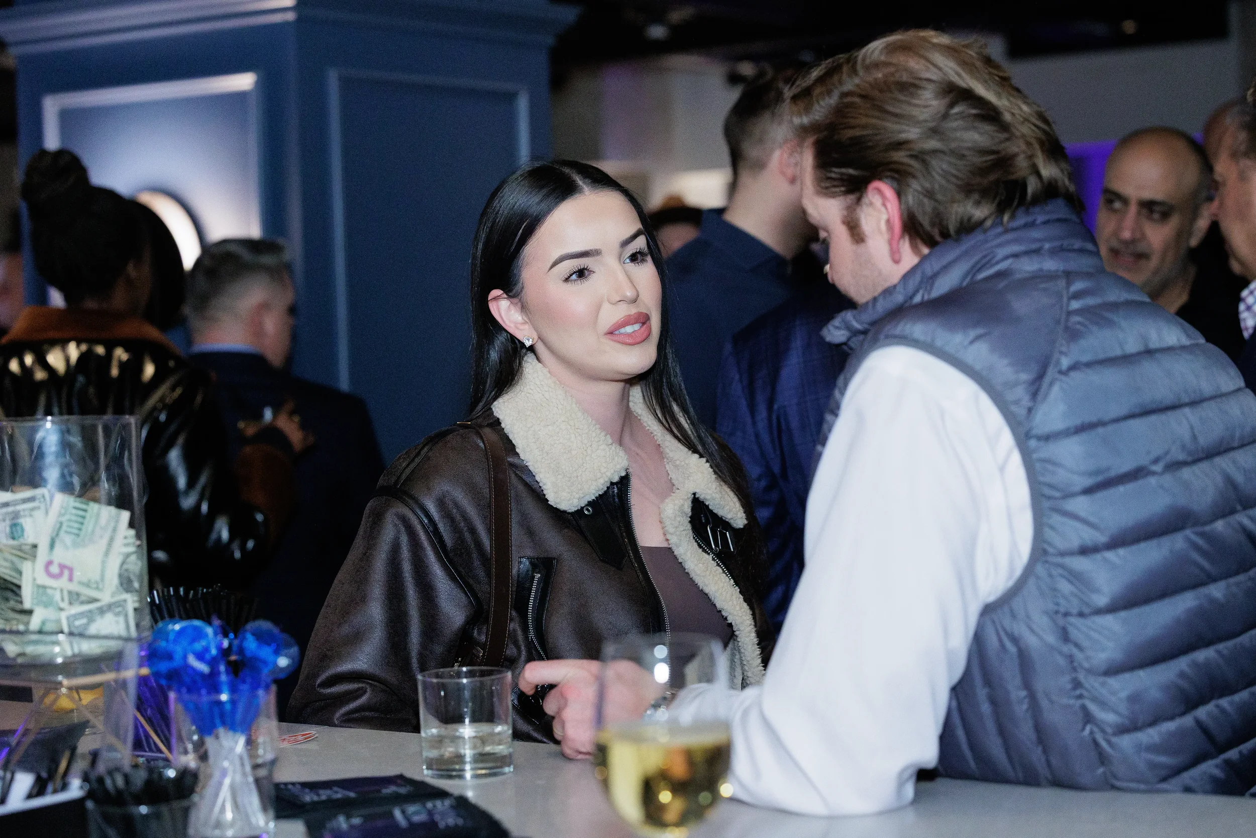 Two attendees chat over drinks at bar during networking reception at Chicago corporate event