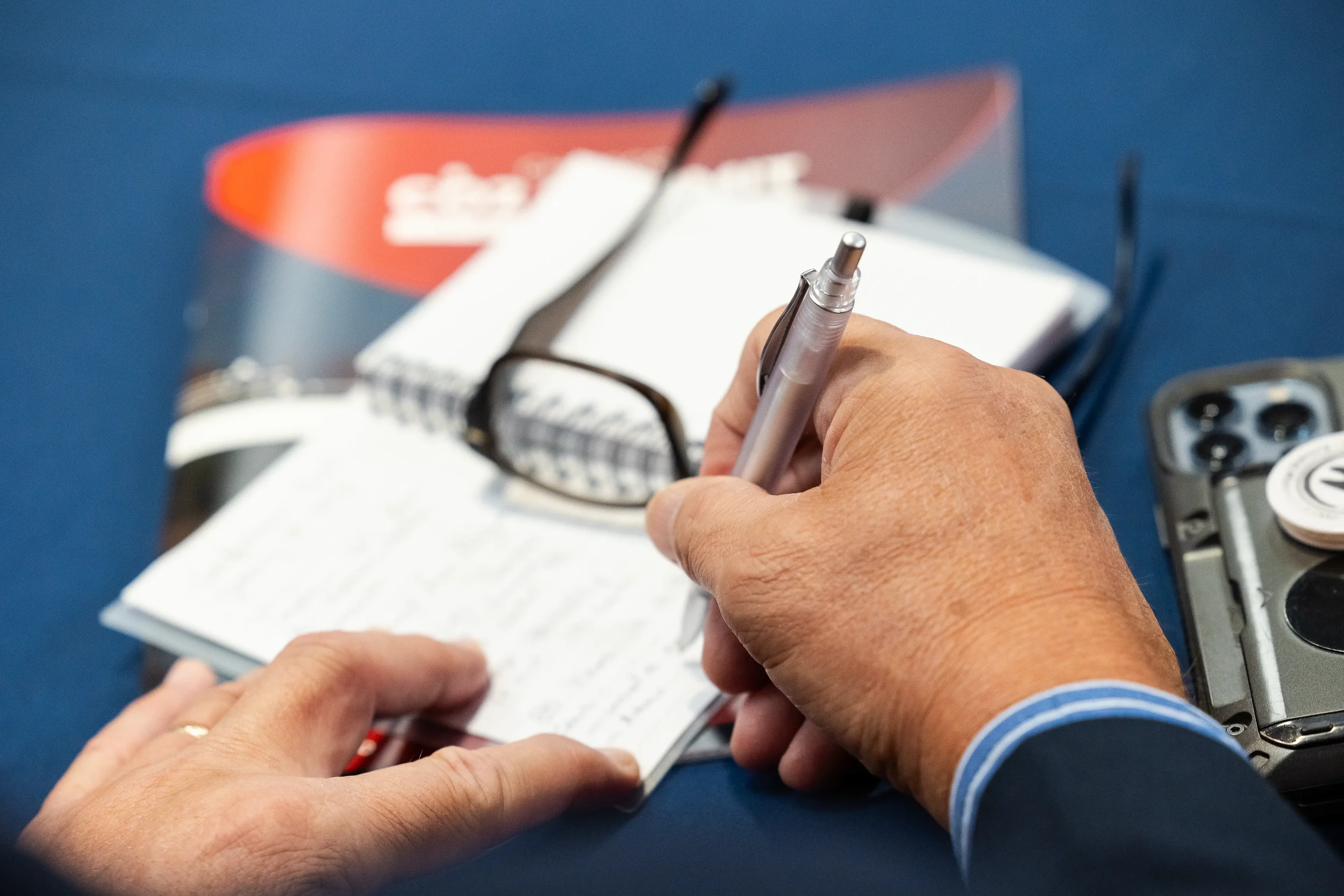 Conference attendee takes handwritten notes during a session at Orlando corporate event