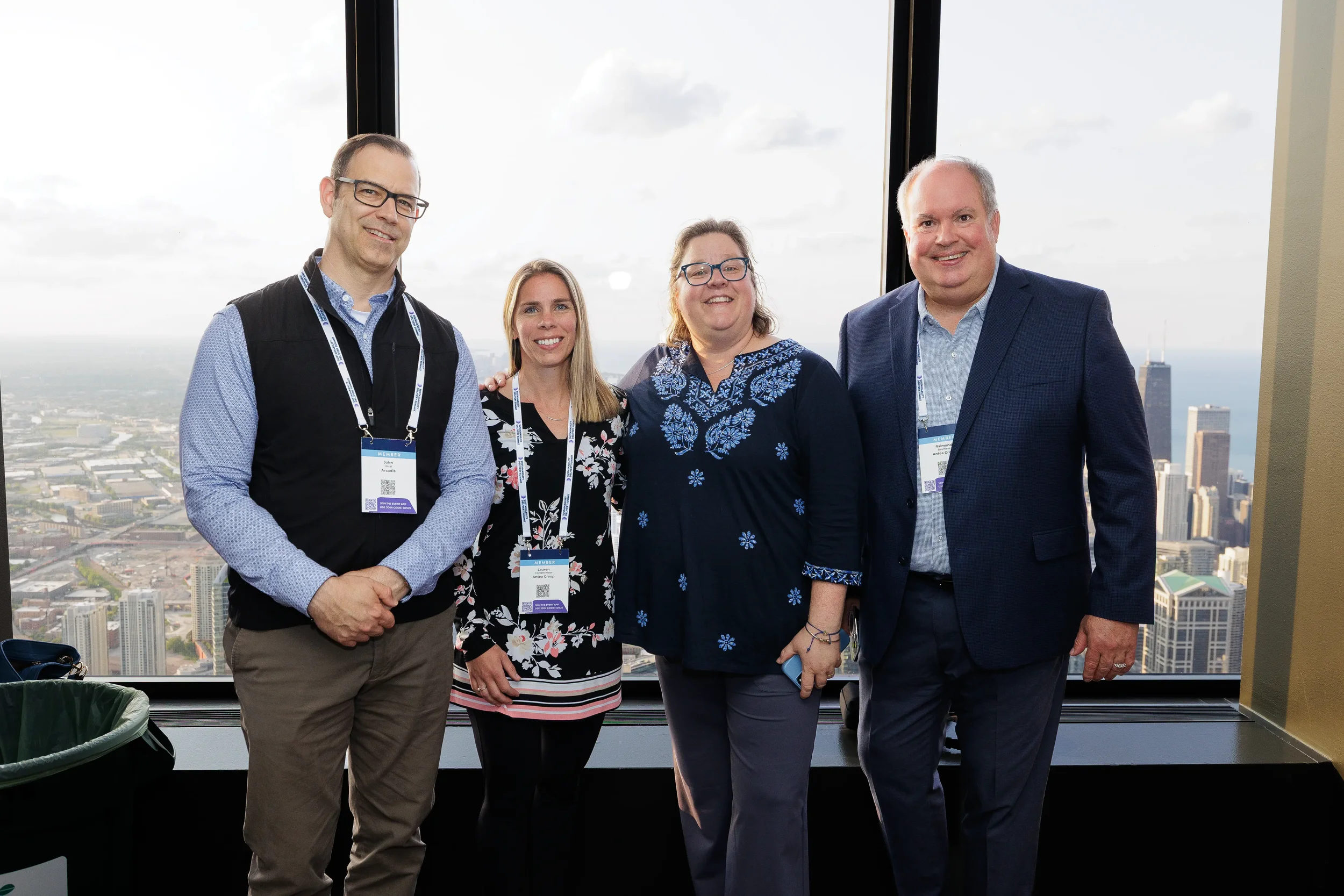 Four attendees pose for group photo with skyline view at Orlando corporate conference