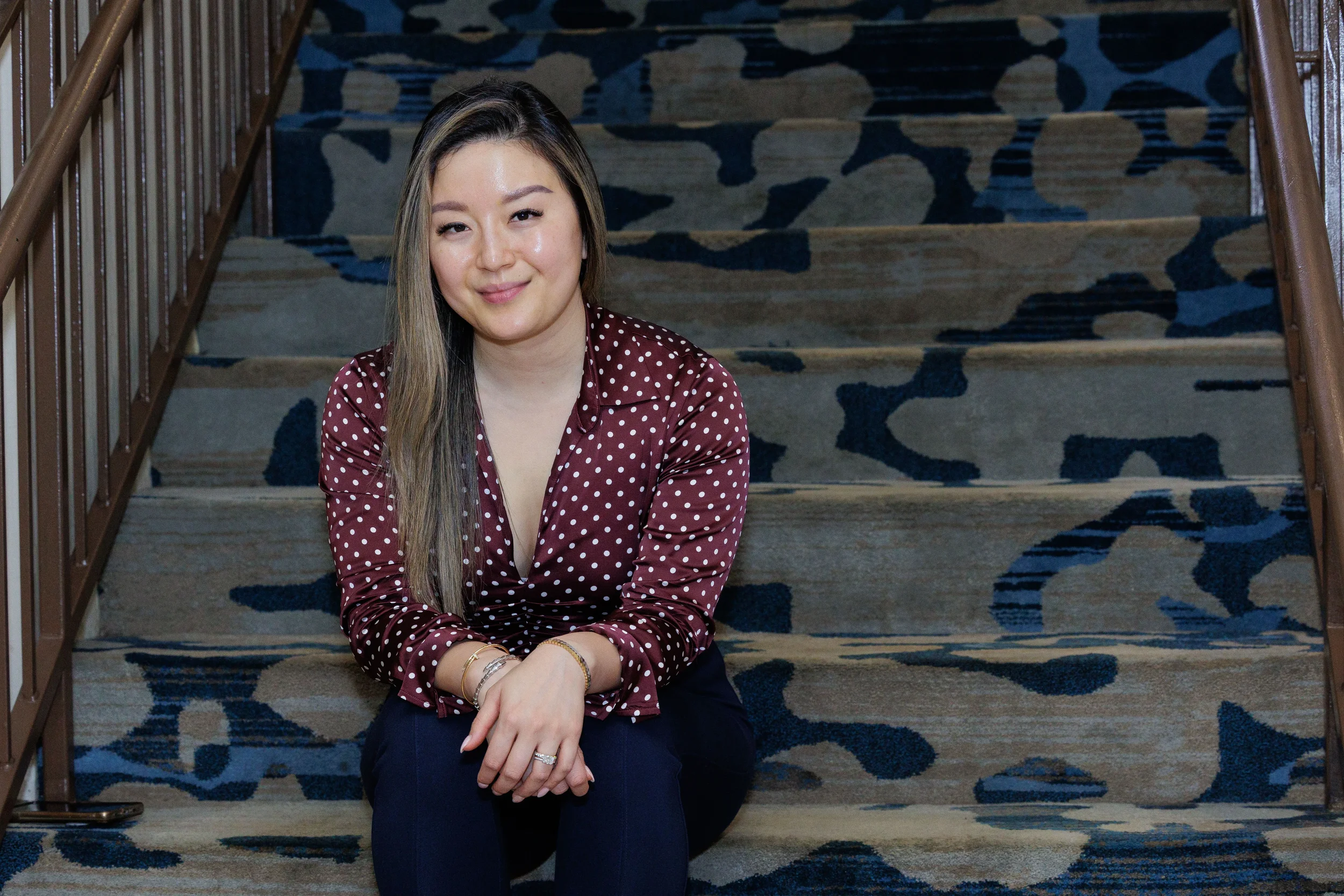 Female conference attendee sits relaxed on patterned hotel staircase at Orlando corporate event