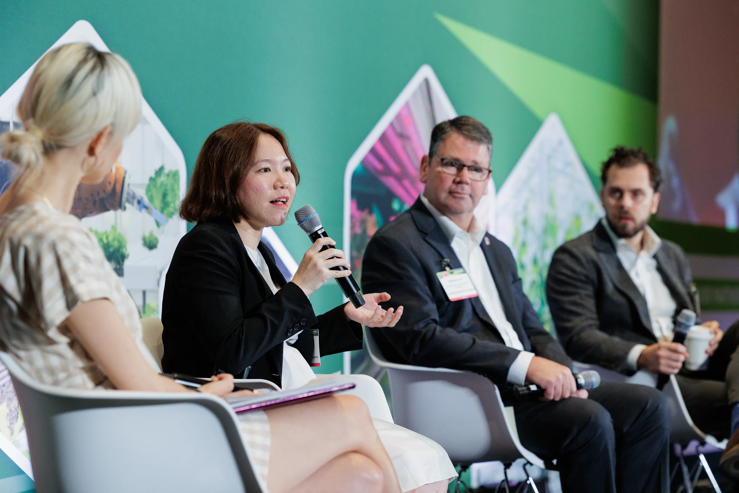 Panelist gestures while speaking into microphone during discussion at Chicago industry conference