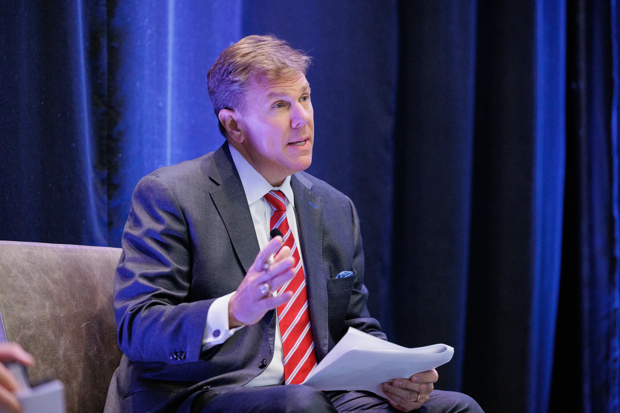 Panelist gestures while speaking on stage during discussion at Chicago industry conference