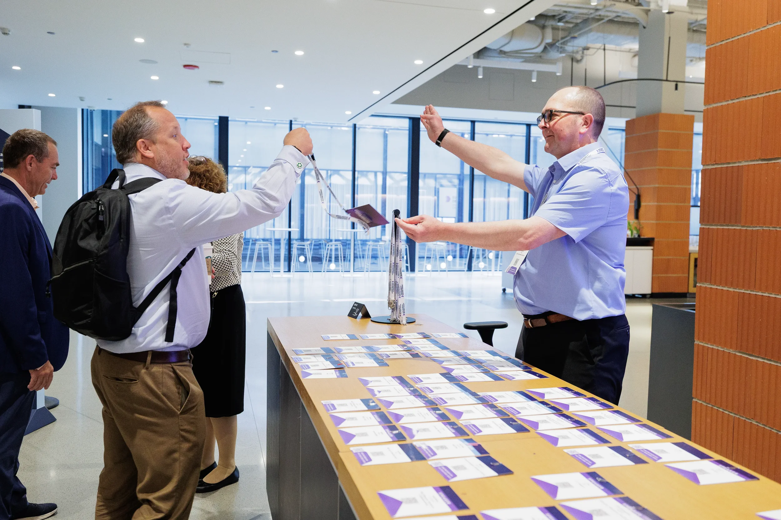 Attendees exchange badges at registration table during Orlando corporate event check-in