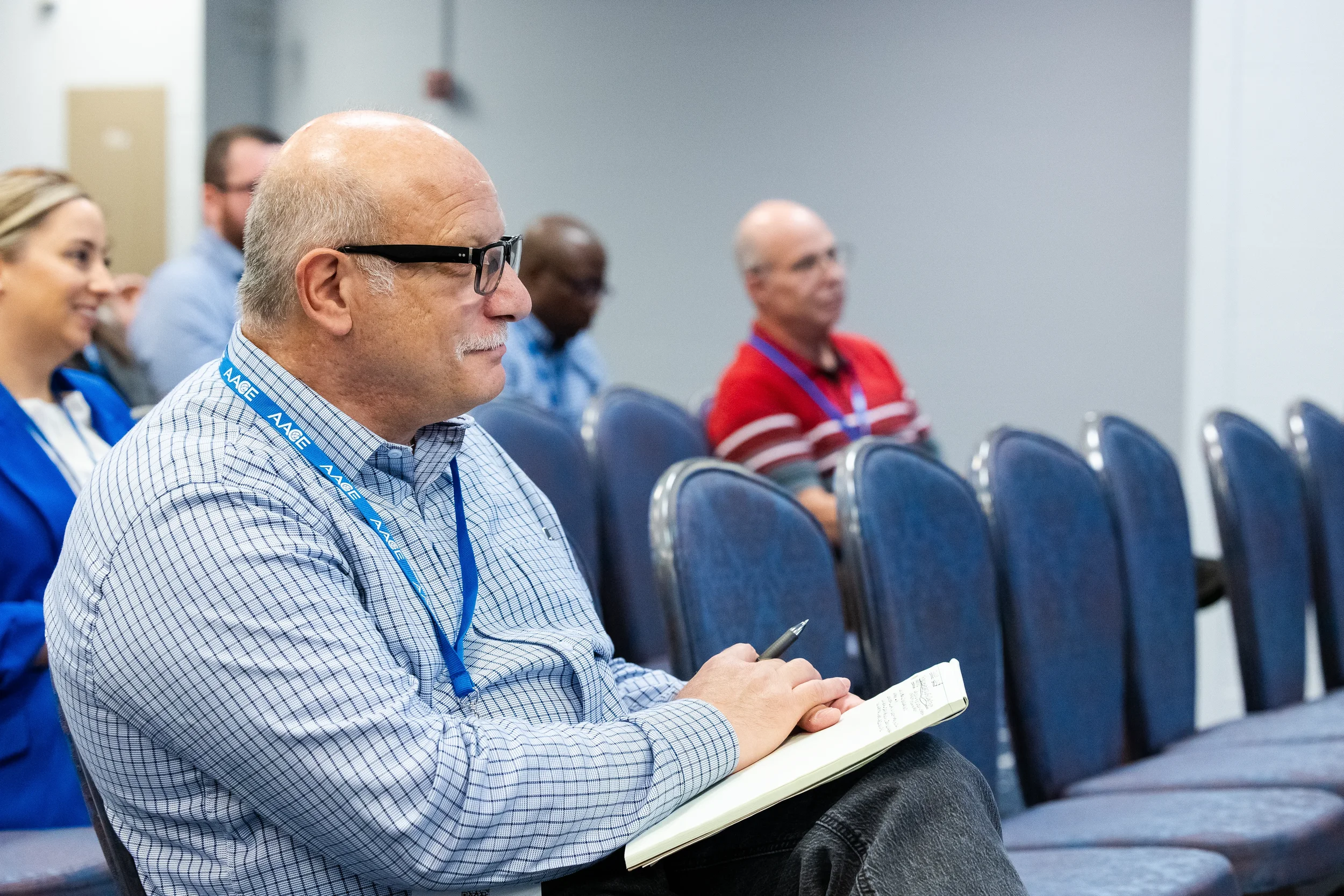 Attendee takes notes while seated in audience at Orlando corporate conference event