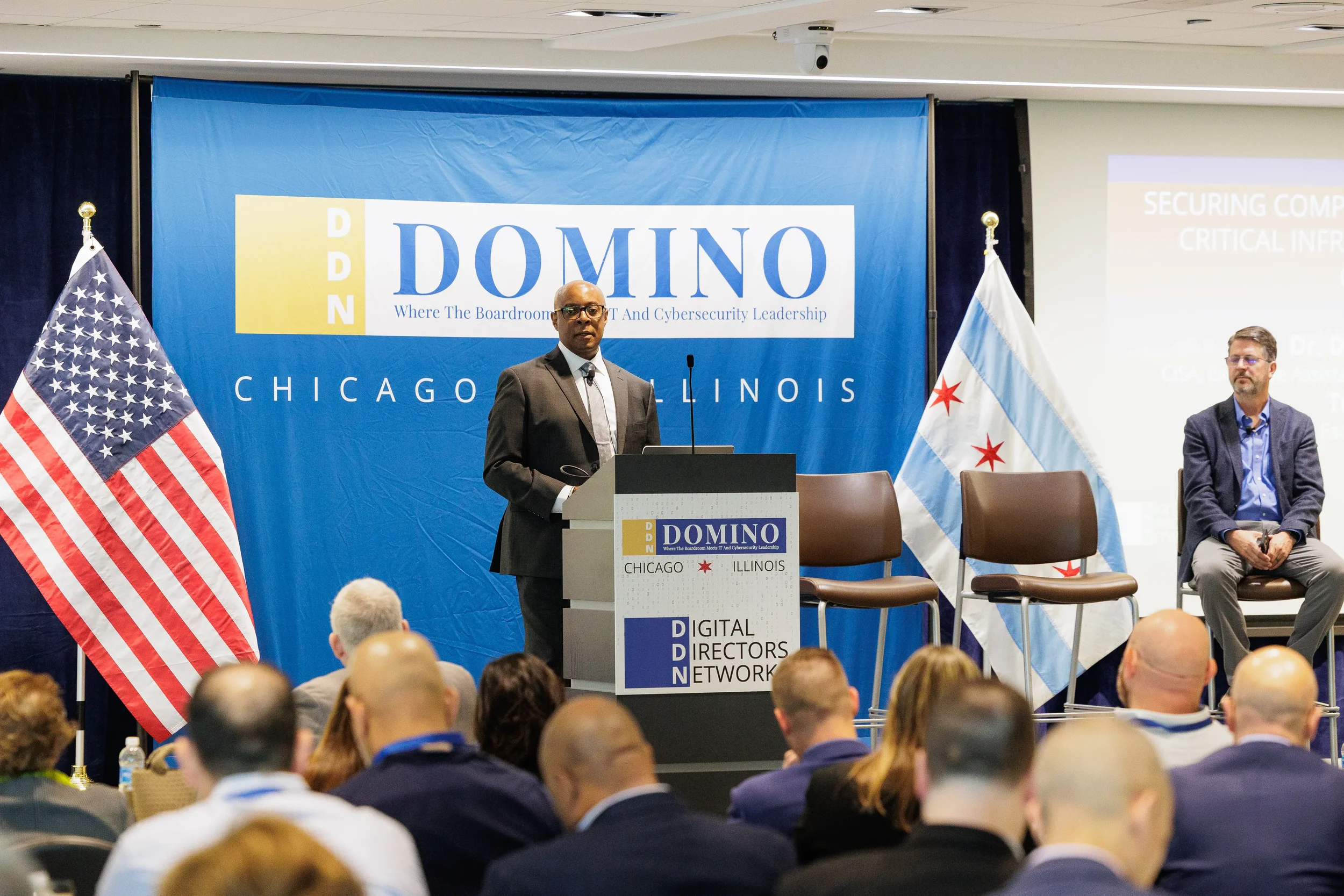 Male speaker presents at branded podium on stage before full audience at Orlando corporate event