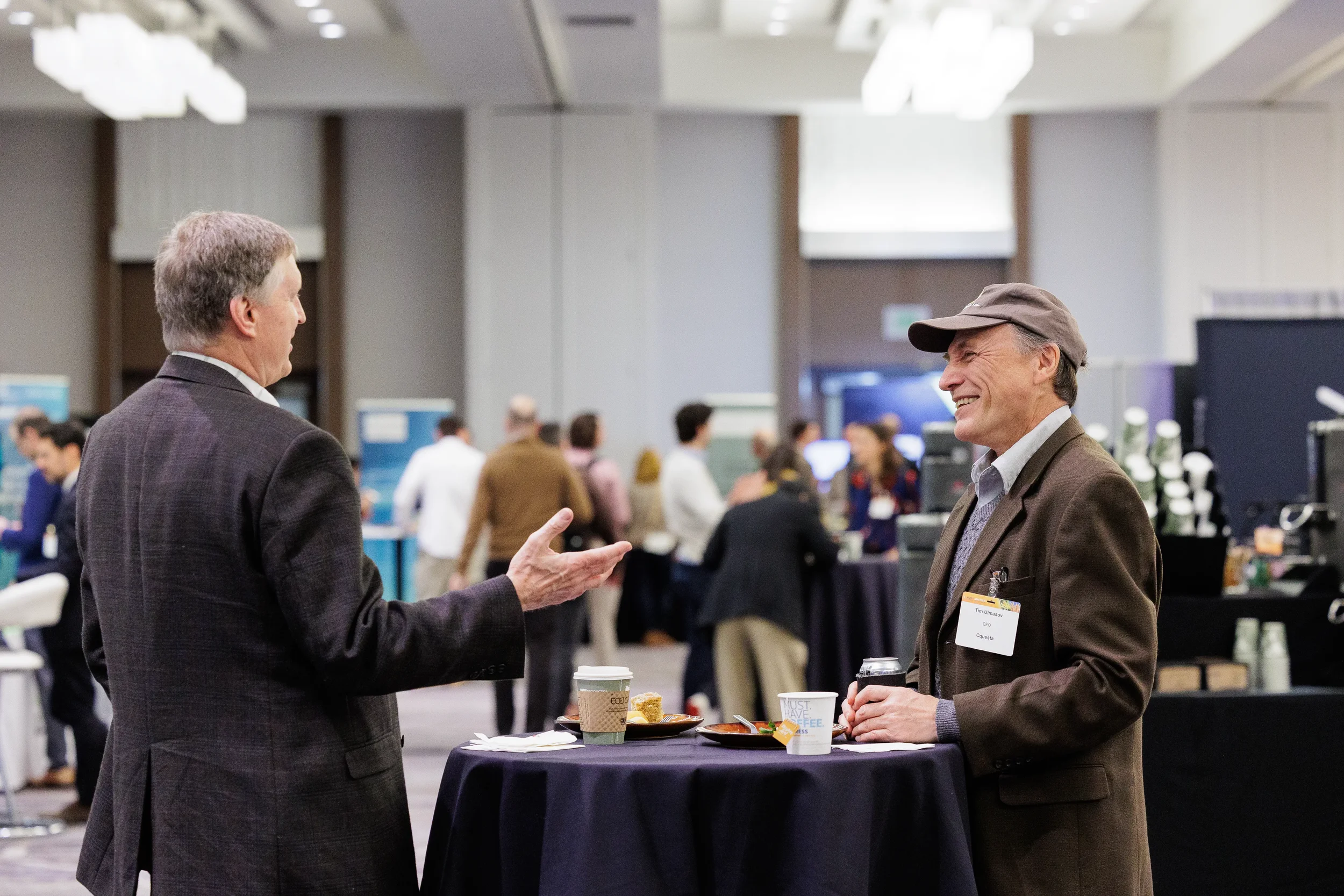 Two badged attendees converse at high-top table on Orlando industry conference expo floor