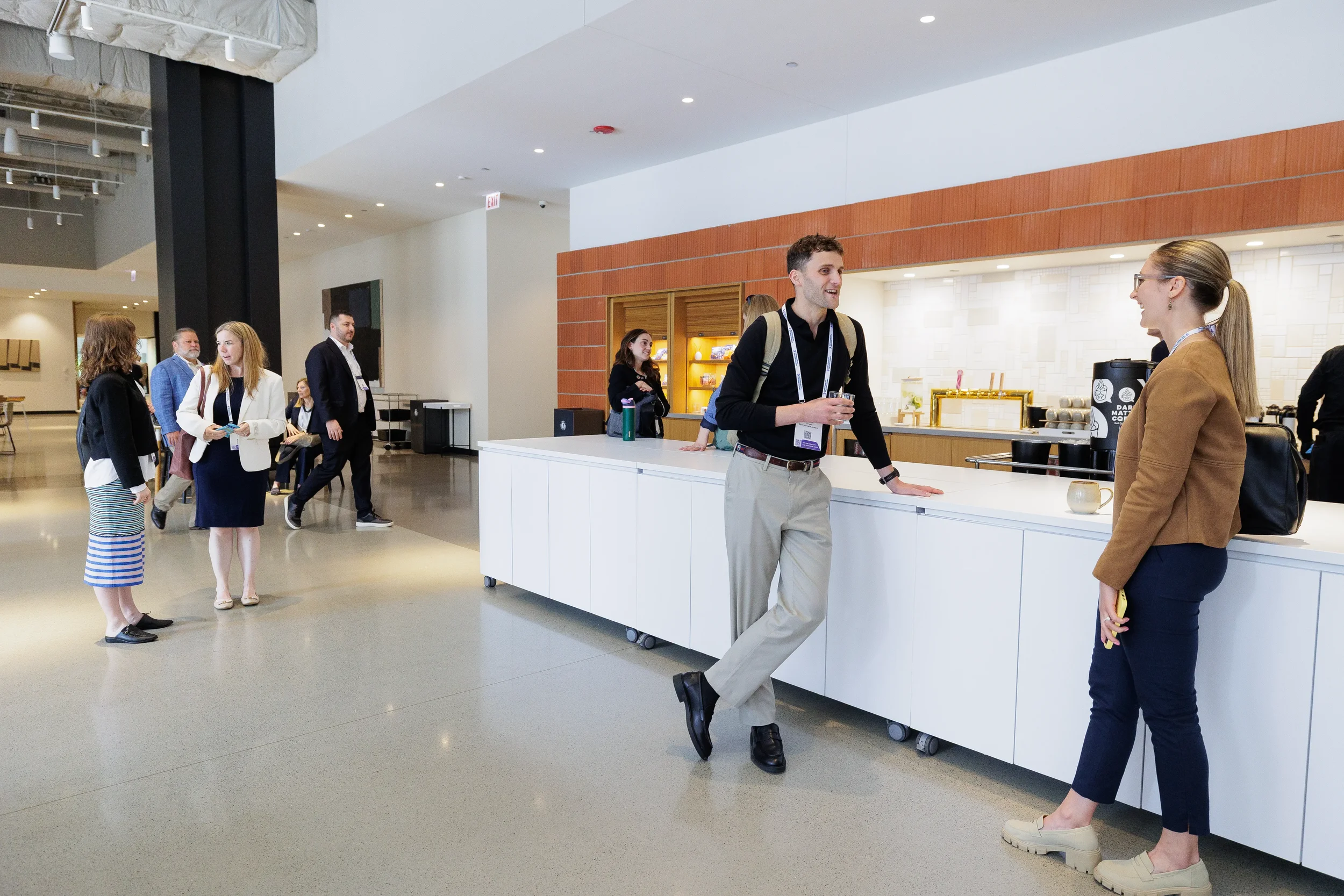 Attendees converse while standing near lobby bar during Orlando industry conference break